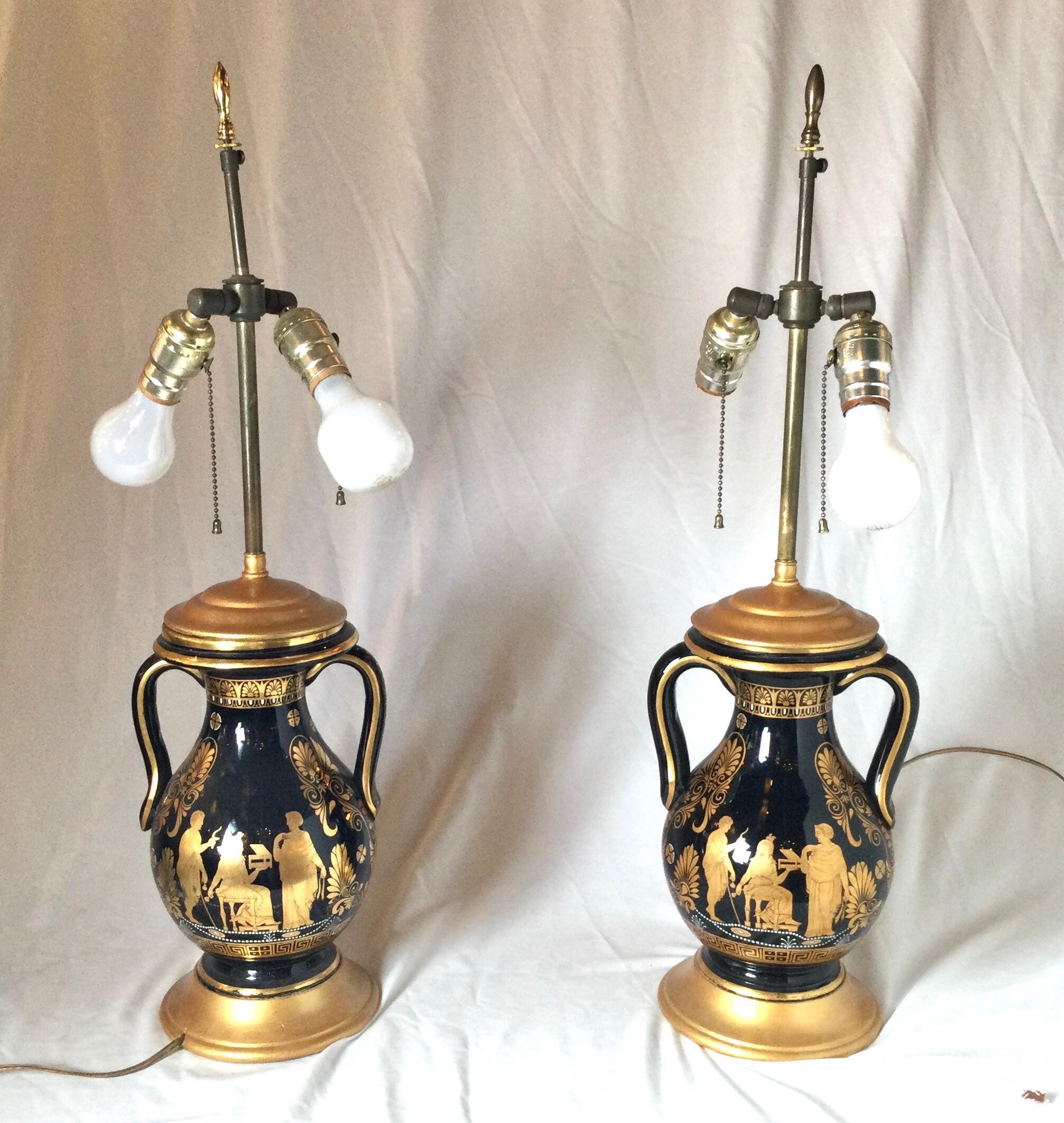A pair of rare back and gold Greek Revival handled urn lamps with gilt decoration. The bodies with draped Greek figures and Greek key and hand applied white bead decoration. The double sockets with an adjustable shade height. The shades are for