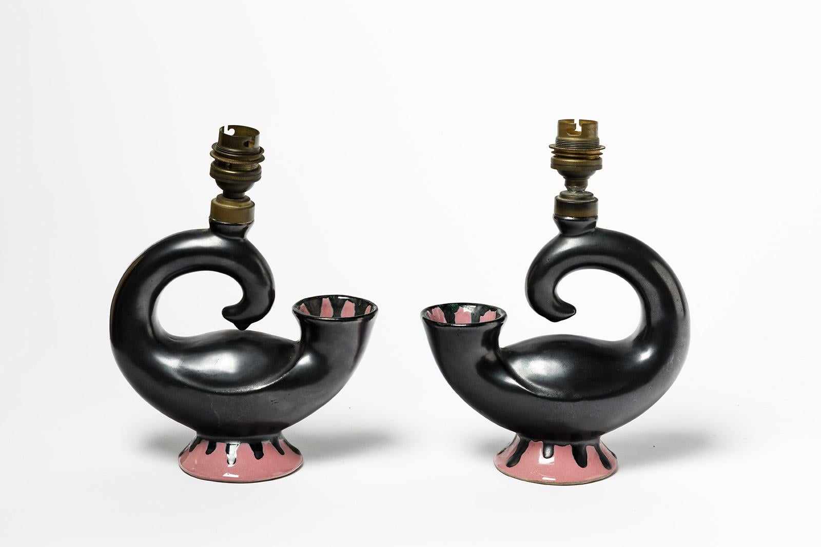 Paire de lampes de table.

Paire de lampes de table originales en céramique des années 50.

Couleurs des glaçures céramiques noires et roses.

Système électrique d'origine.
l'une des douilles est un peu déformée.

Original en parfait