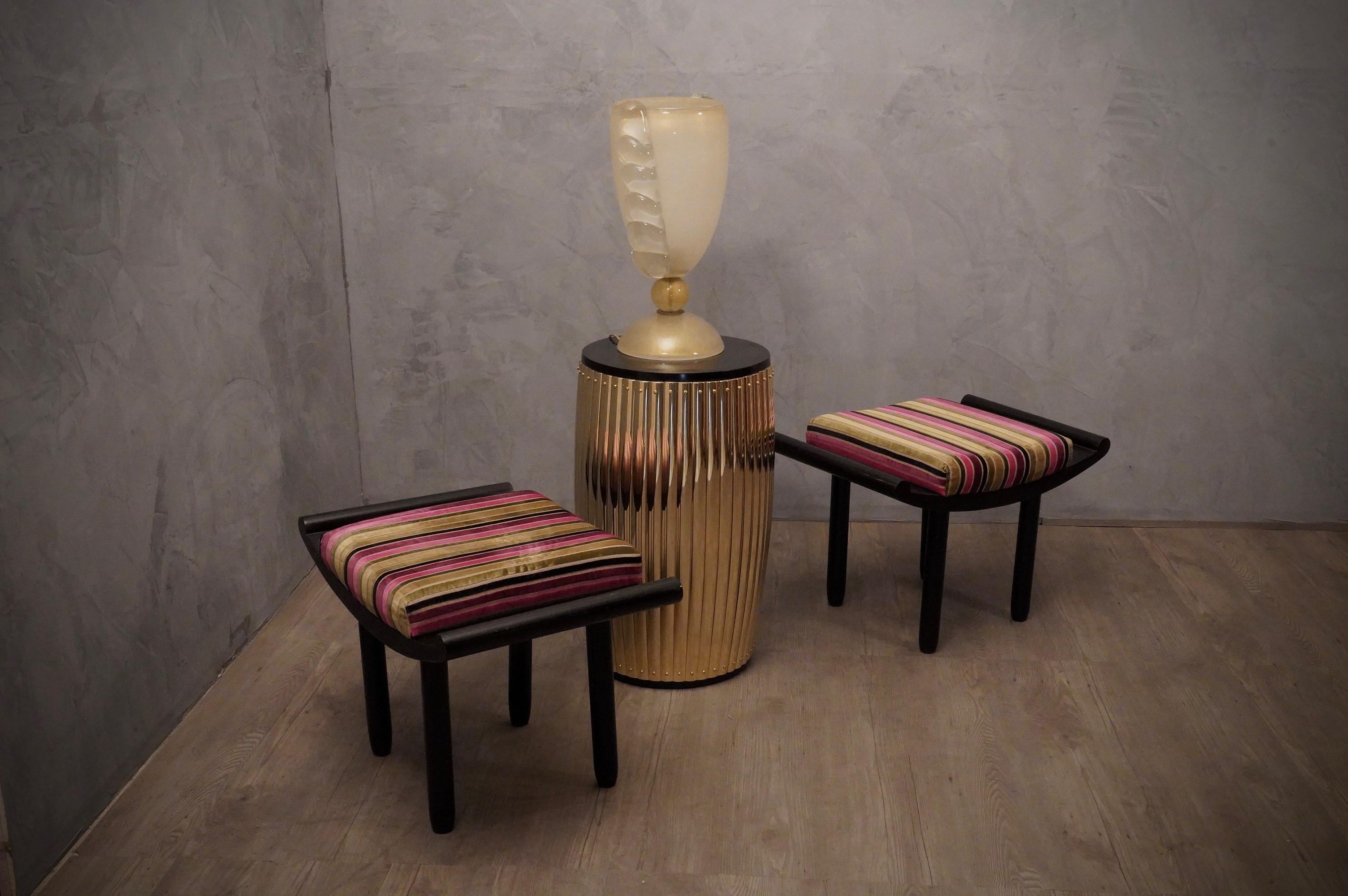 Pair of chinoiserie style stools, all in lacquered wood with black shellac, and enhanced by a splendid and precious multi-colored striped fabric.

French benches, in black lacquered wood. Four cylindrical legs, allow the benches to stay high from
