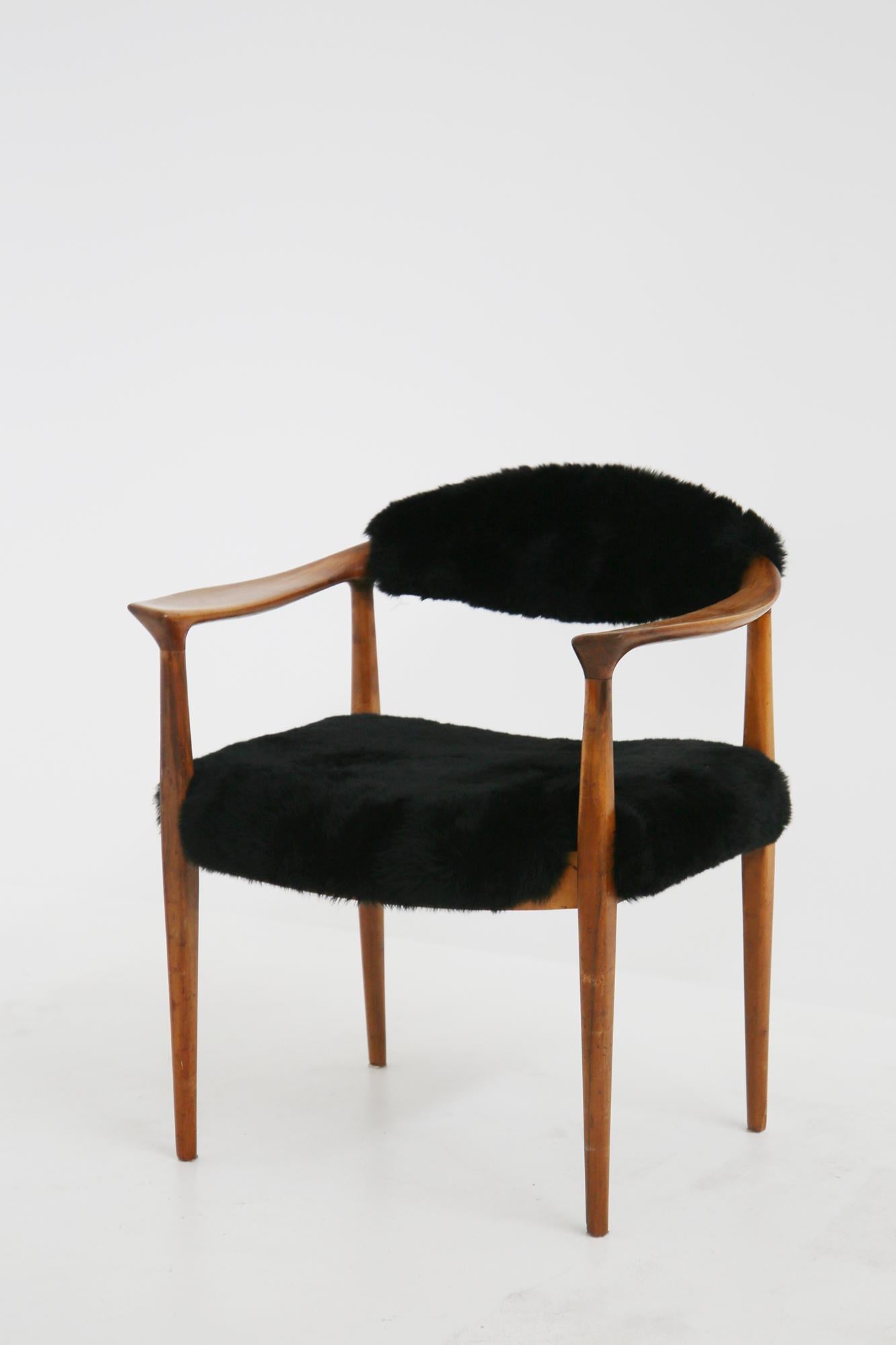 Harmonious pair of armchairs designed by Hans Wegner in 1950. The armchairs are the typical Scandinavian design armchairs, this is recalled by the wood and its essential and rigorous shapes. The seats have been re-lined with a beautiful black