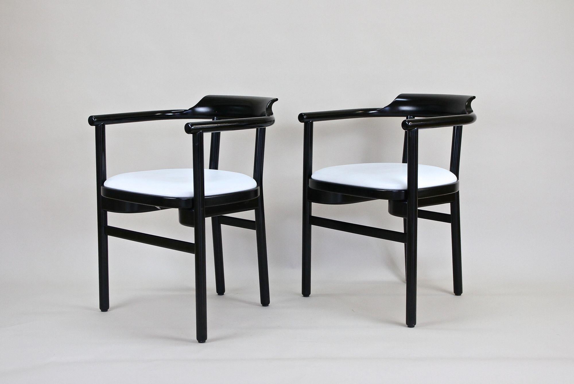 Incredible looking pair of black lacquered armchairs made by the renown company of Thonet Vienna around 1980. These timeless designed black armchairs from the late 20th century impress with elegant lines and were crafted out of fine beechwood. The