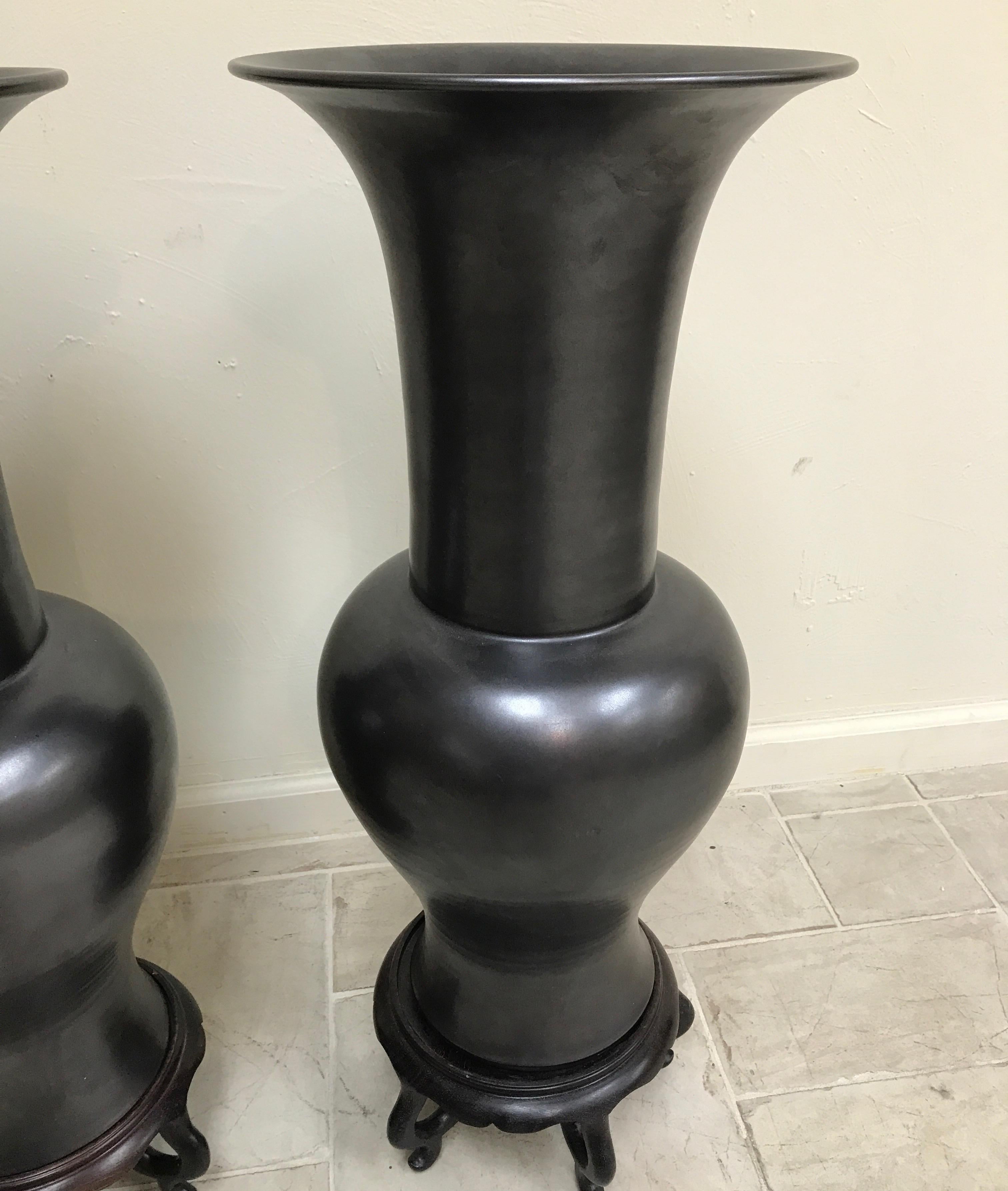 Pair of large Chinese black basalt temple vases on stands.
