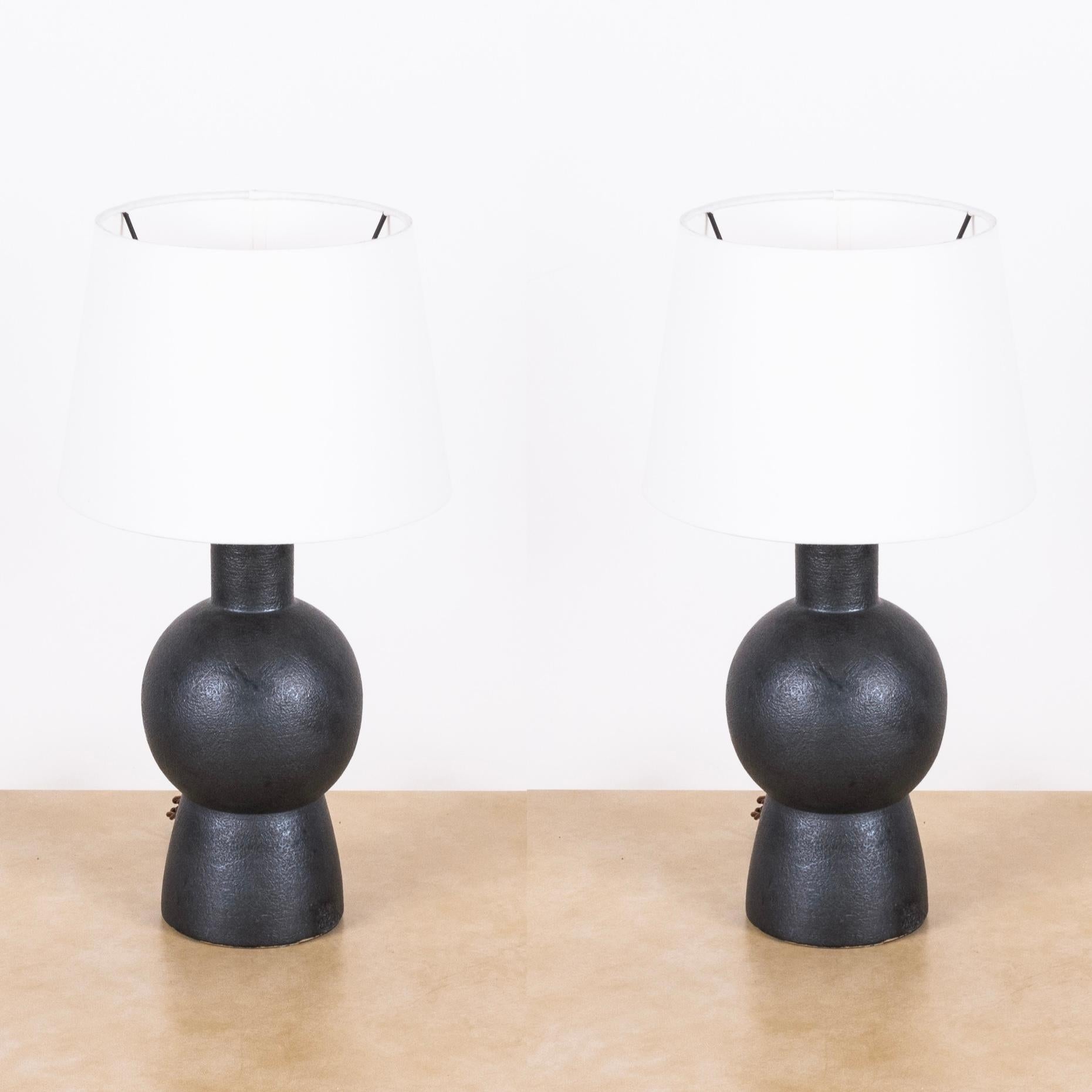 Pair of black 'Bilboquet' stoneware lamps by Design Frères.

Dimensions listed (10 in. diameter x 18 in. tall) are the overall dimensions of the lamps plus the shades (as pictured). The lamp bases are 11 in. tall and the shades are 7 in. tall.