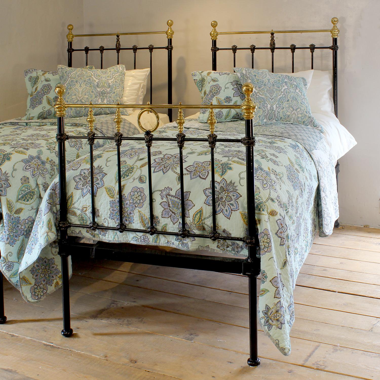 A stunning matching pair of 19th-century Victorian single beds, each crafted from iron and finished in an elegant black with polished brass accents and rings. Measuring 89.5cm wide each, these beds feature beautifully detailed castings, brass