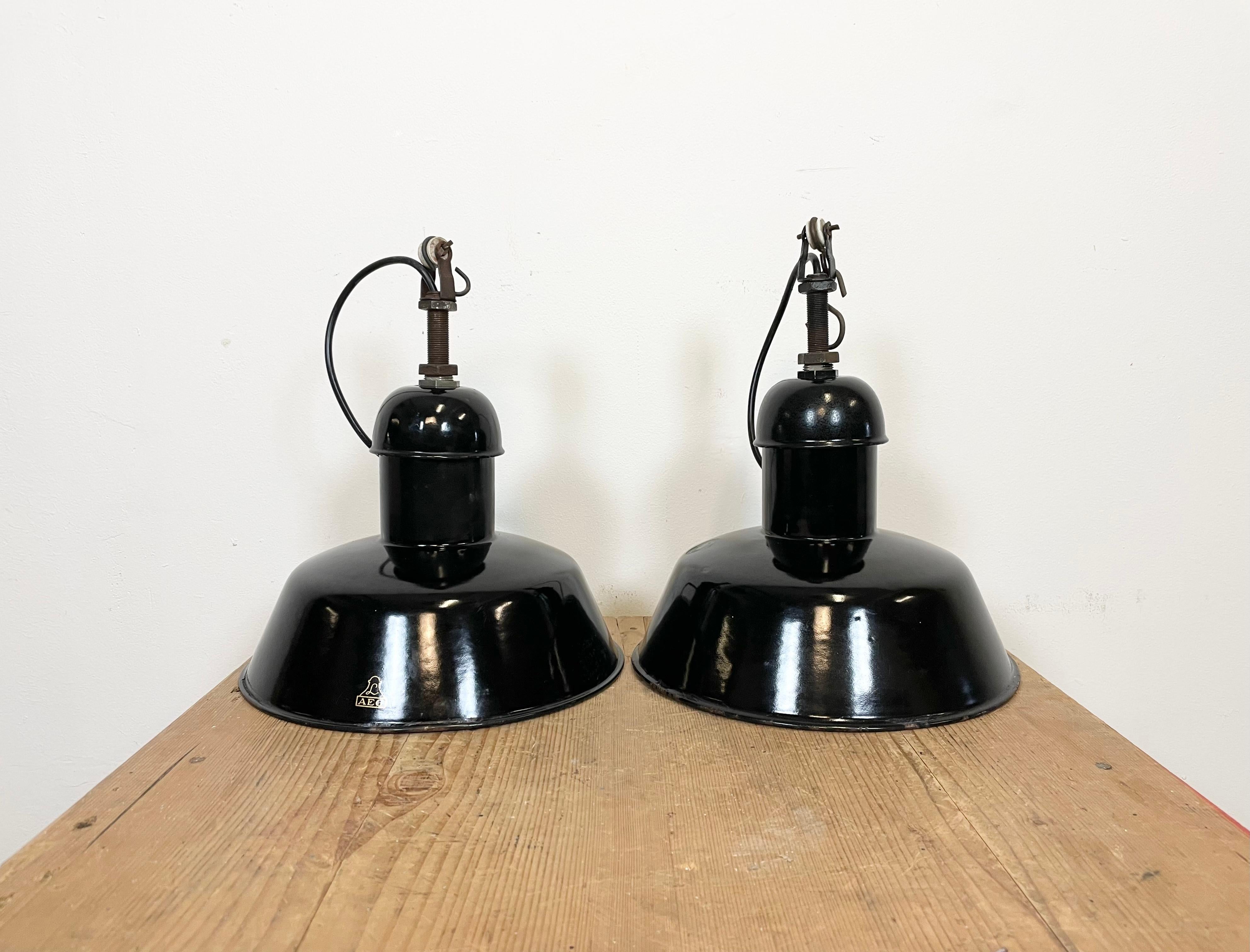 - Vintage Industrial factory lamps from the 1930s 
- Made by AEG in Germany
- Black enamel shade with white enamel interior
- Iron top 
- Socket requires E 27 lightbulbs 
- New wire 
- Lampshade diameter: 28 cm
- Weight : 1 kg
The AEG emblem