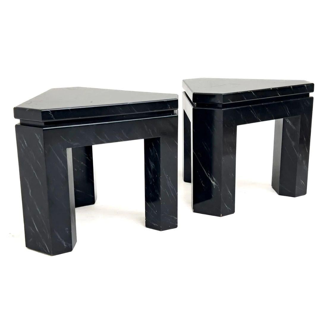 This pair of side tables features a bold triangular shape, offering a modern and geometric design. Each table is finished completely in a faux black marble, exuding a stylish and contemporary edge. The chunky, angular structure of the tables is