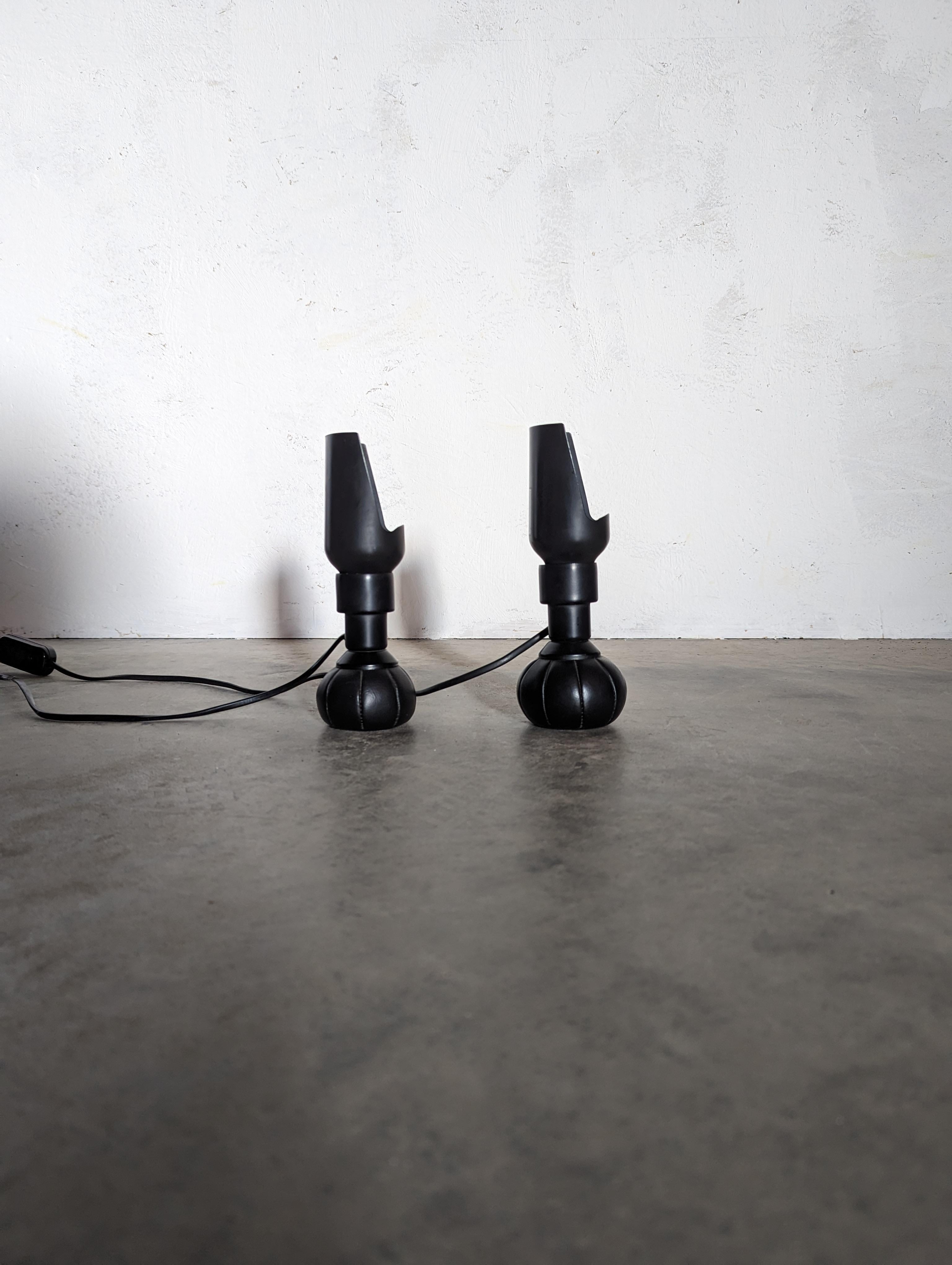 A pair of black 600/P adjustable model by Gino Sarfatti for Arteluce
the 600 model, a direct light table lamp designed in 1966, has a base of a pouch made of sky leather filled with little small balls. This base allows the unit to be positioned in