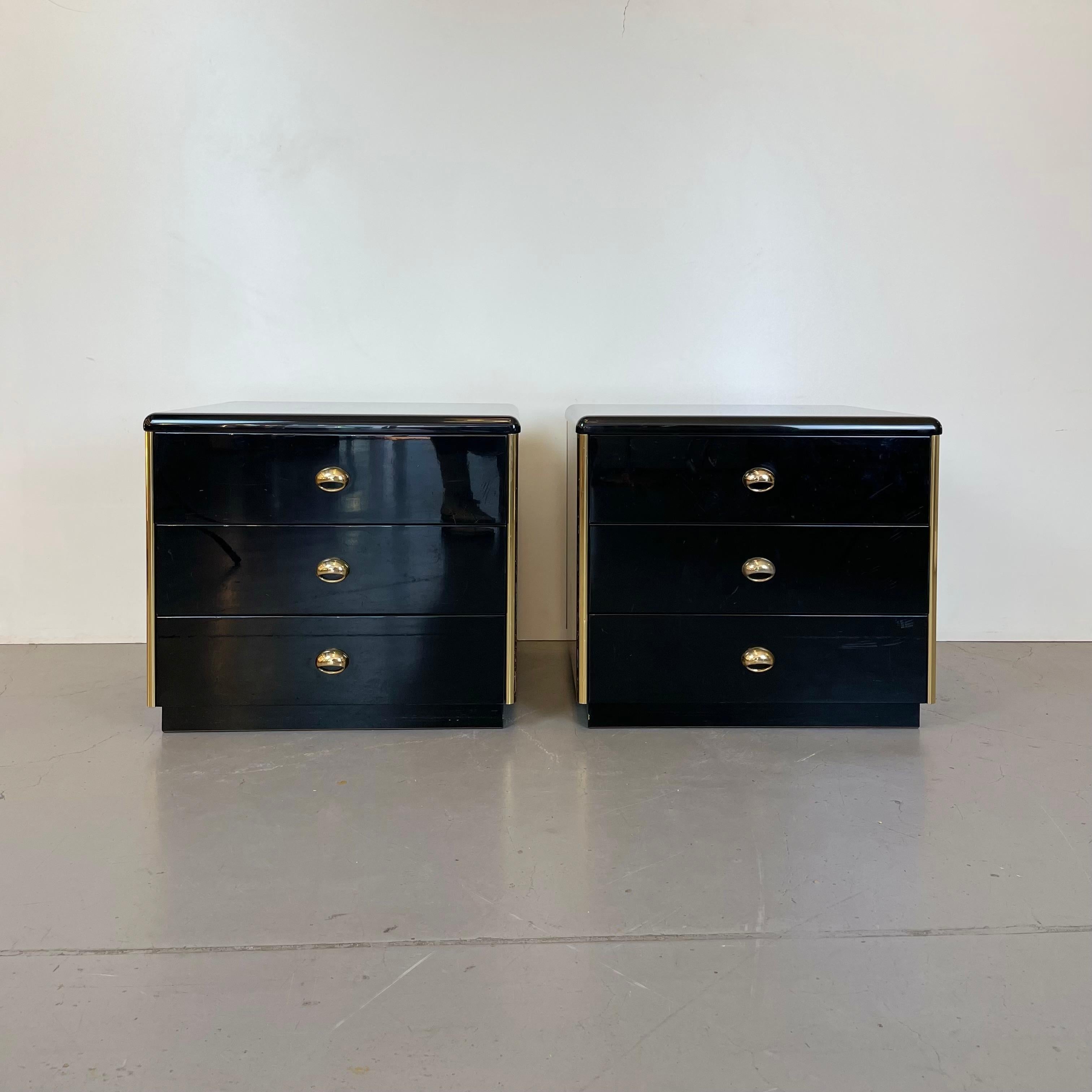 Ensemble de deux tables de chevet en bois laqué noir brillant et chants et bouton en métal doré, dont trois tiroirs en bois foncé, conçu dans les années 1980.
-
Ensemble de deux tables de chevet en bois laqué noir brillant et bords et bouton en