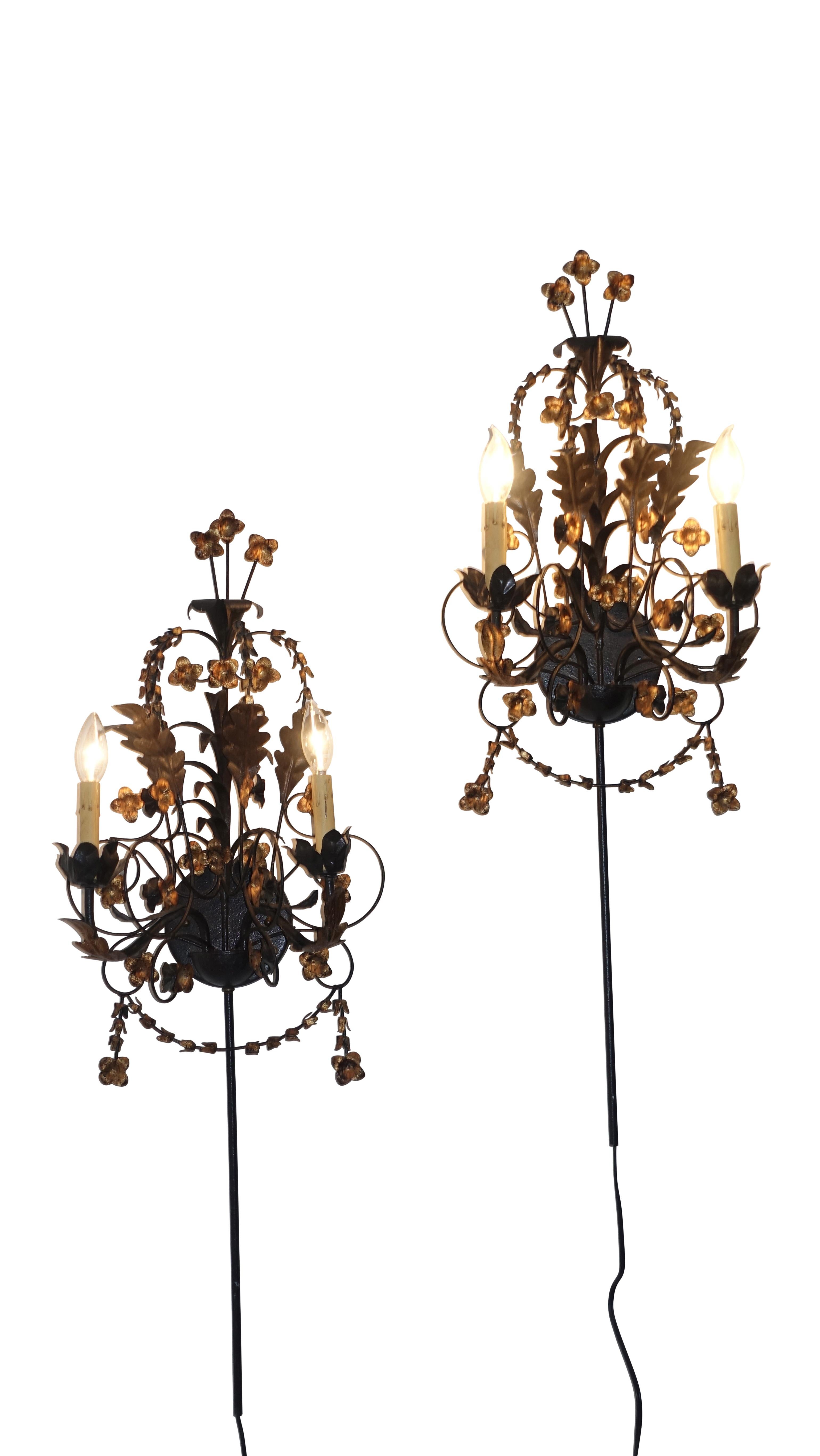 A pair of black iron wall sconces with gold tole flowers and leaves. Recently re-wired with candelabra base sockets, American, circa 1950s.
