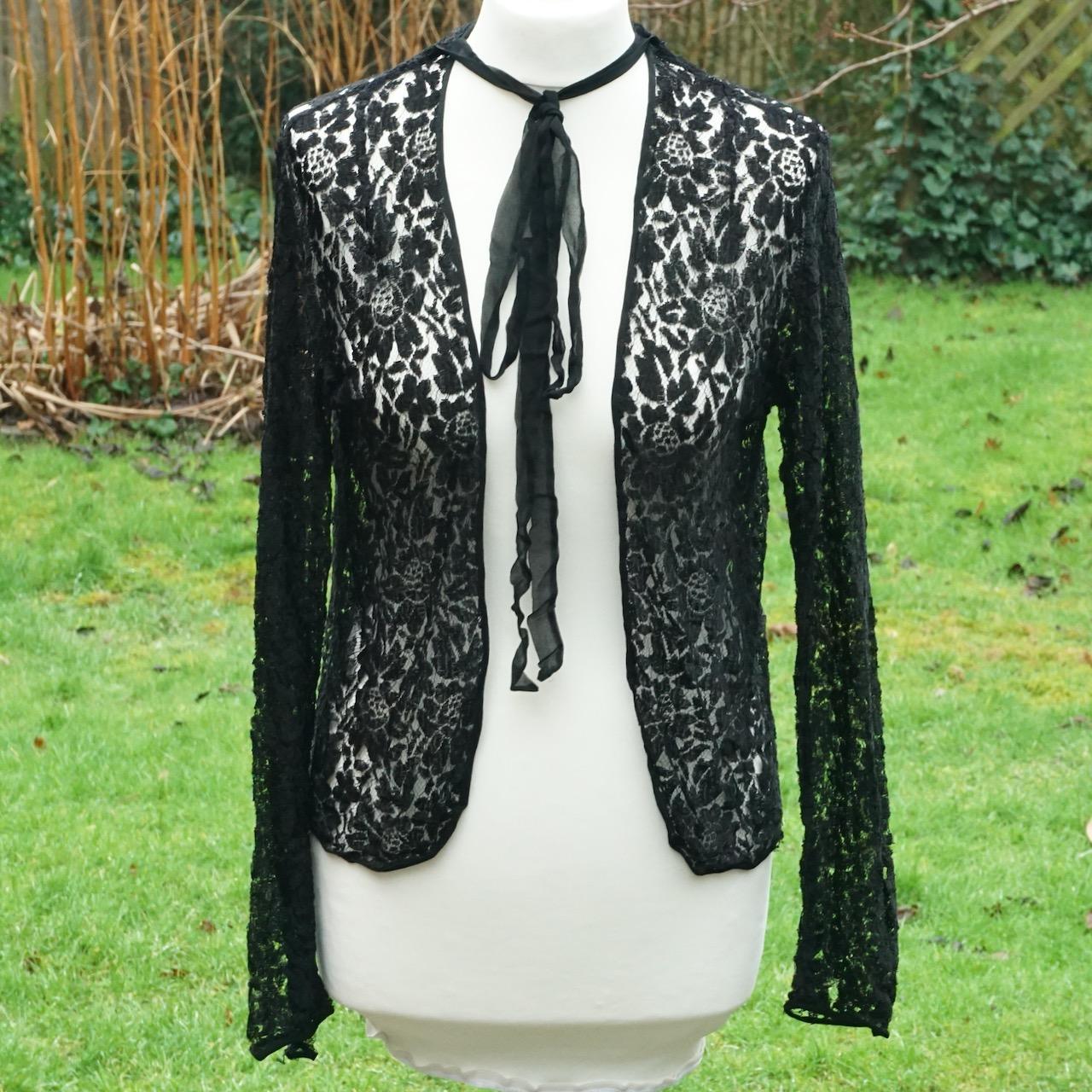Bellissimo paio di giacche in pizzo nero con disegni floreali. Circa anni '30.

La giacca stile bolero ha un grande disegno floreale in pizzo e maniche lunghe in pizzo a strati che si chiudono al polso con bottoni automatici. Misura il busto 34