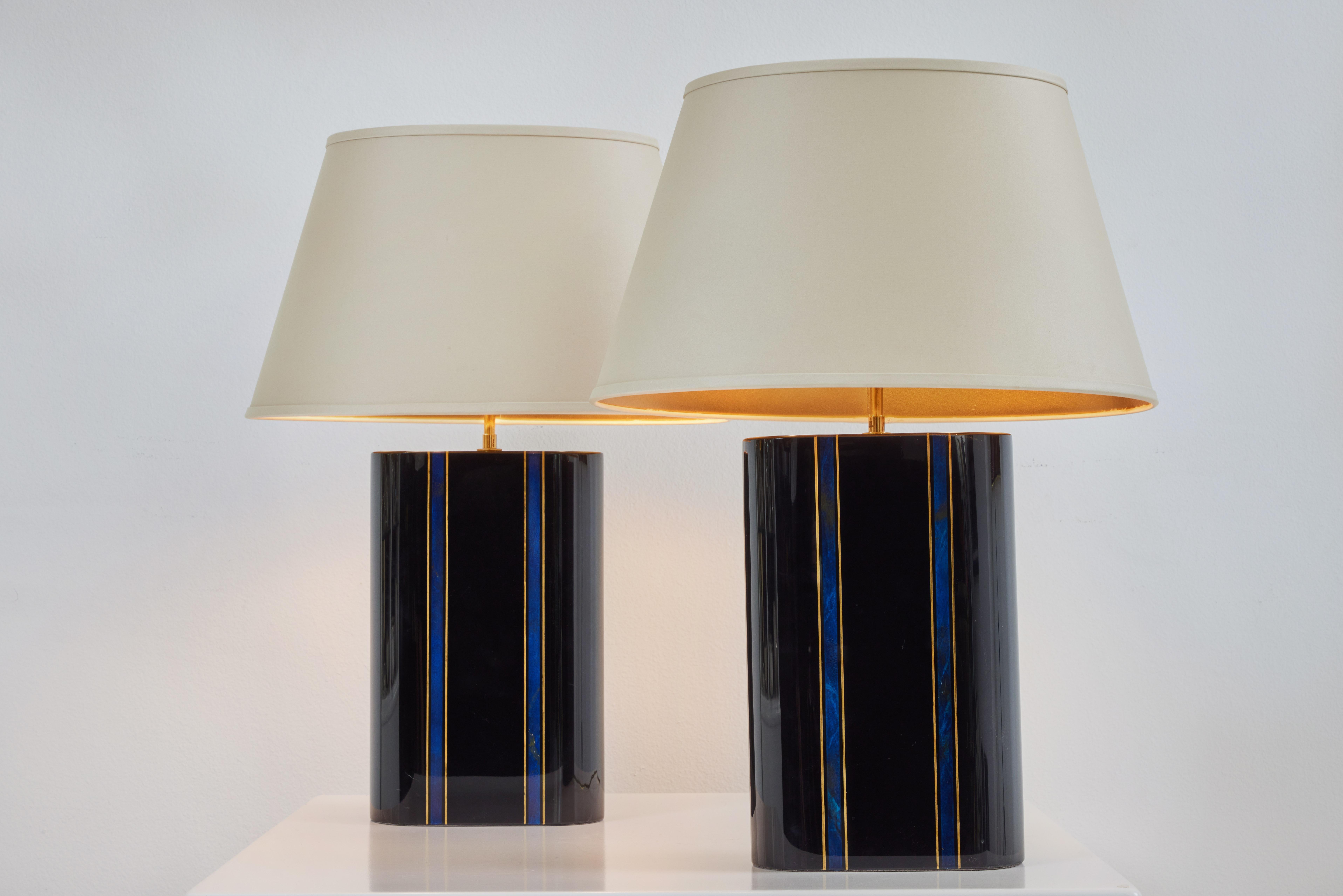 A beautiful pair of lamps a classic Karl Springer design. the lacquer bodies are in very fine condition and the faux details of lapis and gold is a wonderful detail. The shades are original to the lamps and are in great condition finished in a cream