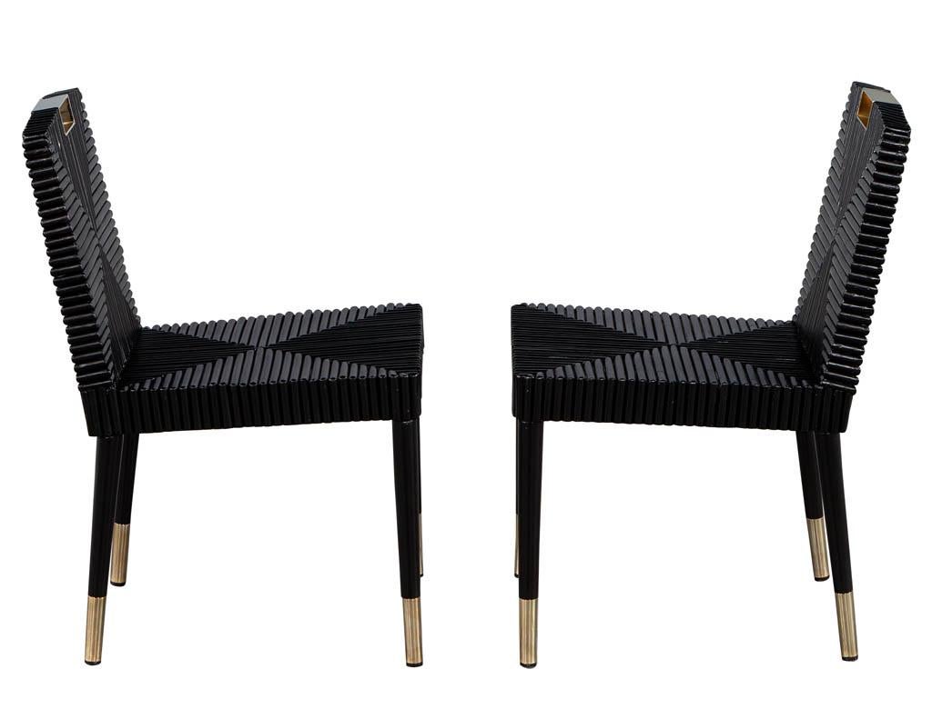 Pair of black lacquered accent side chairs. Featuring unique design with metal accented tops and feet. Chairs are in good condition with extremely minor wear on metal consistent with use. Price includes curb side delivery to the continental USA.