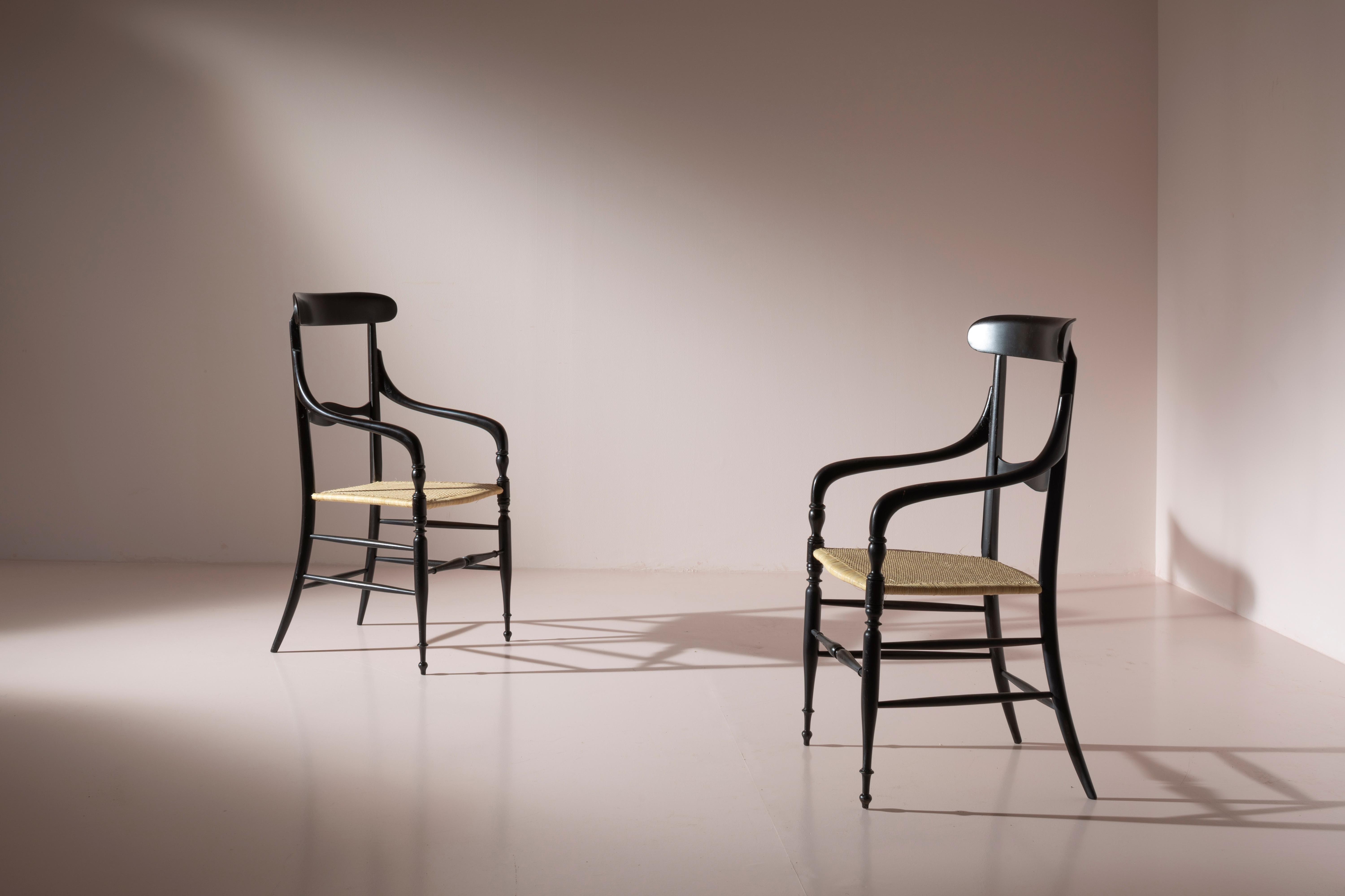 Paire de fauteuils Campanino produits par Enzo Rotella, en bois de hêtre teinté et en paille, fabriqués à Chiavari, Italie, dans les années 1950.

La large assise et les accoudoirs incurvés caractérisent cette paire de fauteuils Campanino fabriqués