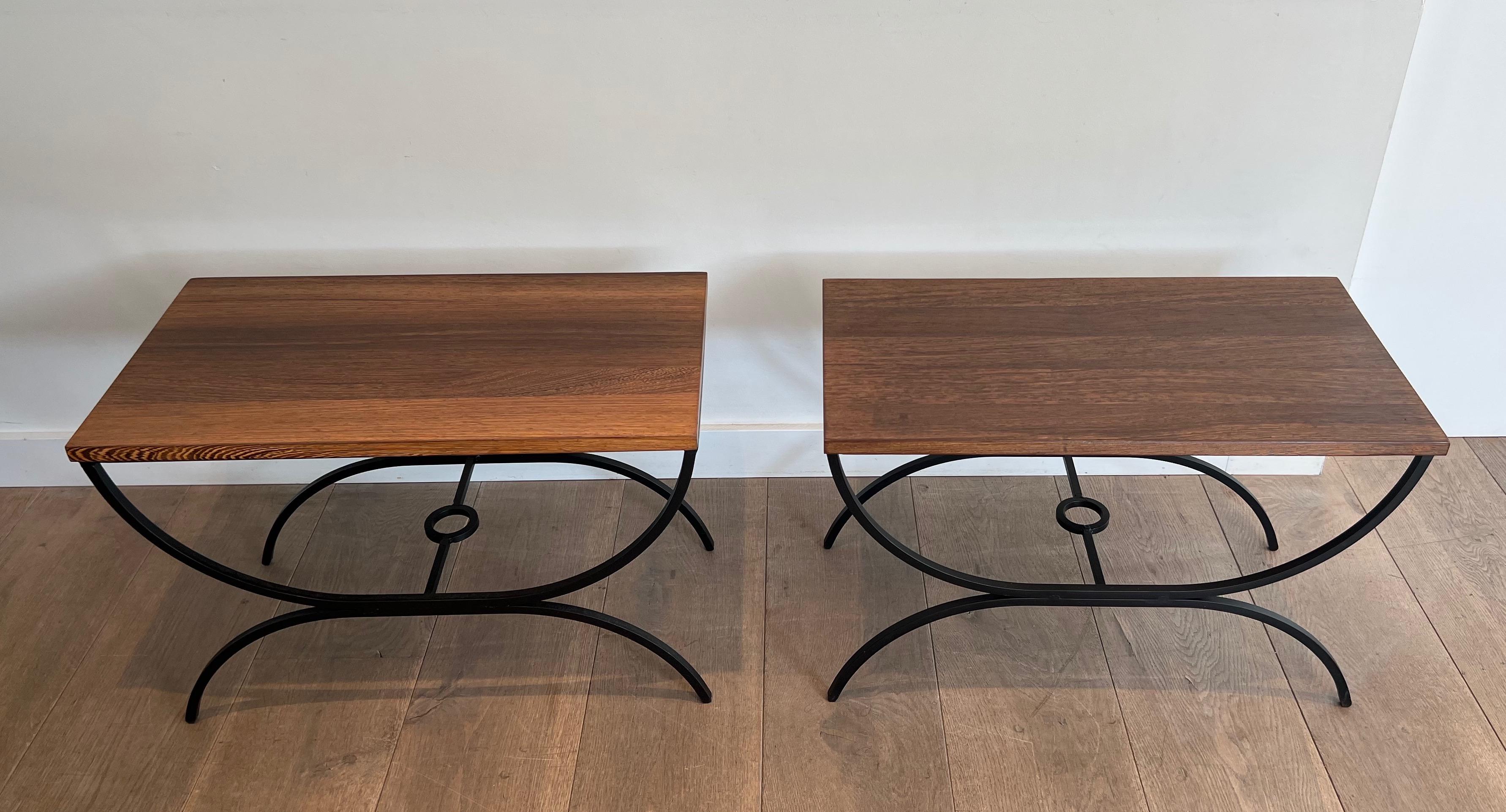This pair of side tables is made of a black lacquered metal base with and exotic wood stop. This is a French work. Circa 1950.