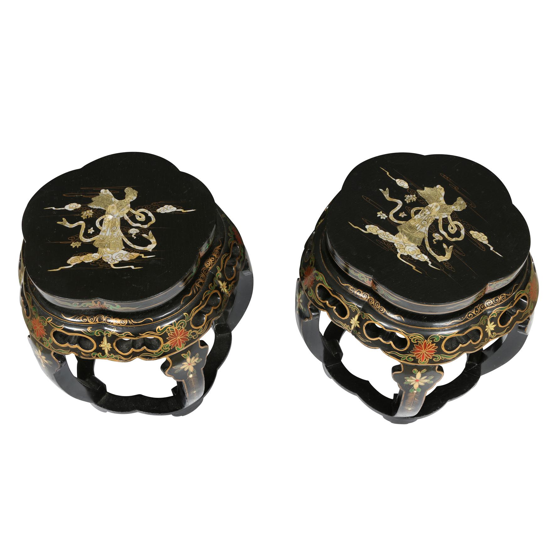 A pair of black lacquered mother of pearl inlay tabourets featuring a figure on top and floral motif decorating the sides