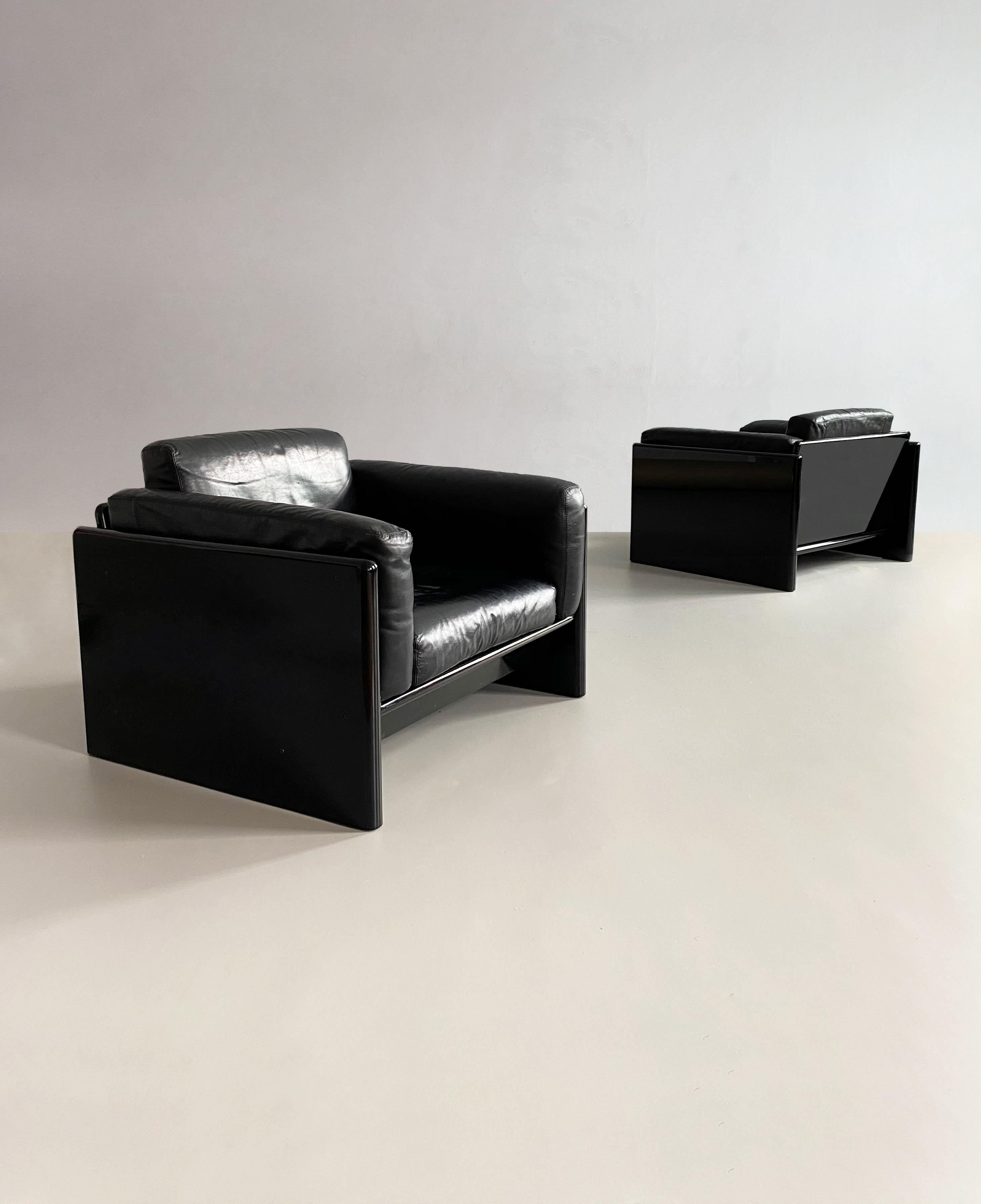 Pair of rare, exquisite, piano black 'Simone' armchairs designed by prolific Italian design influencer Dino Gavina (founder of Flos and Gavina) for Studio Simon in the 1970s.

Dimensions (cm, approx): 
Height: 70 
Width: 94 
Depth: 81 
Height