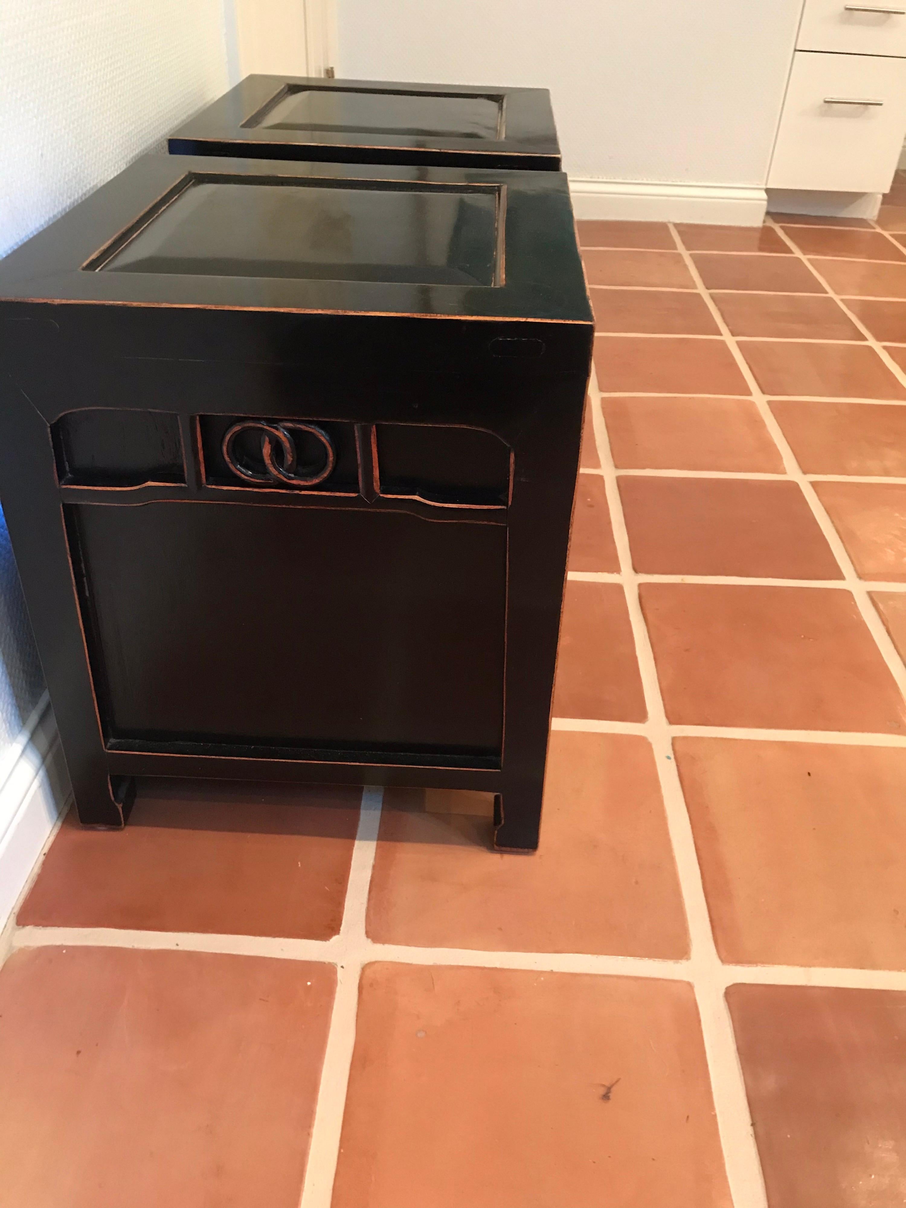 This is a pair of black lacquered wood end tables or nightstands 
Have two drawers in each table and are well constructed 
They have an Asian inspired look.