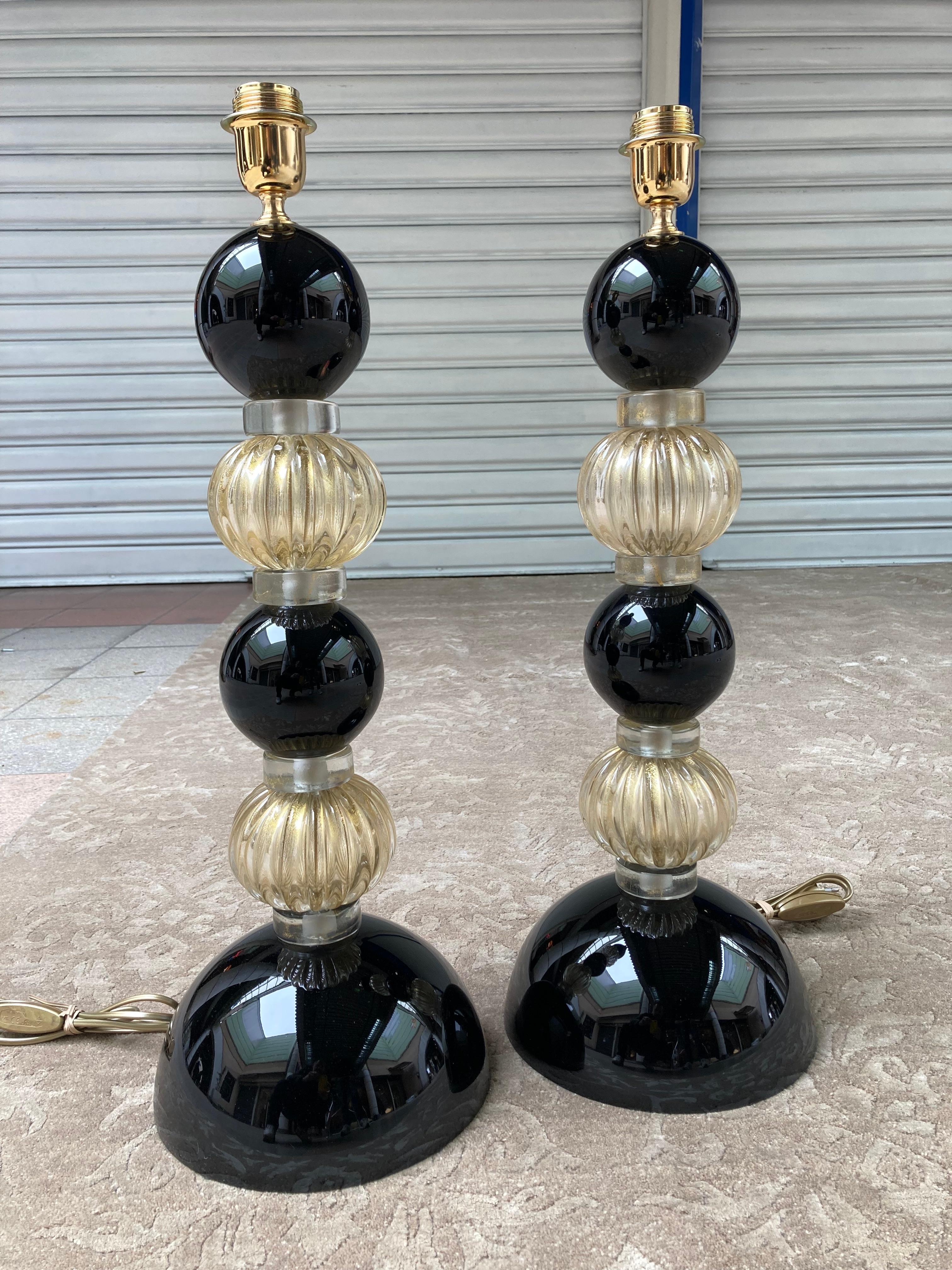 Pair of black lamp bases - Signed Toso.
Murano glass.
Circa 1980.
Measures: H 63 x D 23 cms.
Signed at the foot.
Shower feet with alternating spheres in ribbed glass and smooth glass.
In perfect condition / Electrical operation OK.