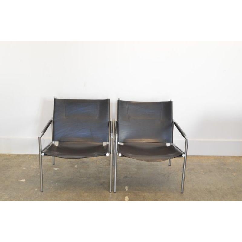 Pair of Martin Visser lounge chairs in black leather

MFG: Spectrum, Holland 1965 / model SZ02

Dutch modernist chairs with chromed metal frame and thick black saddle leather seat and backrest. One chair is from the first production series. The