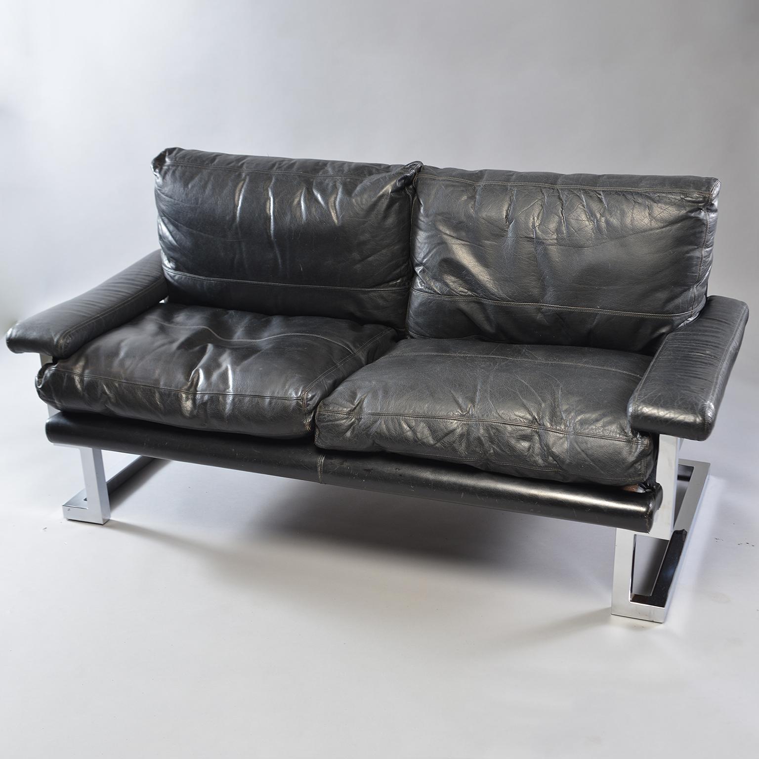 Pair of black leather and chrome sofas designed by Tim Bates for the Mandarin Collection of UK furniture maker Pieff & Co, circa 1970s. Comfortable with Classic midcentury lines and style. Padded arm rests, pebble finished leather and chromed steel