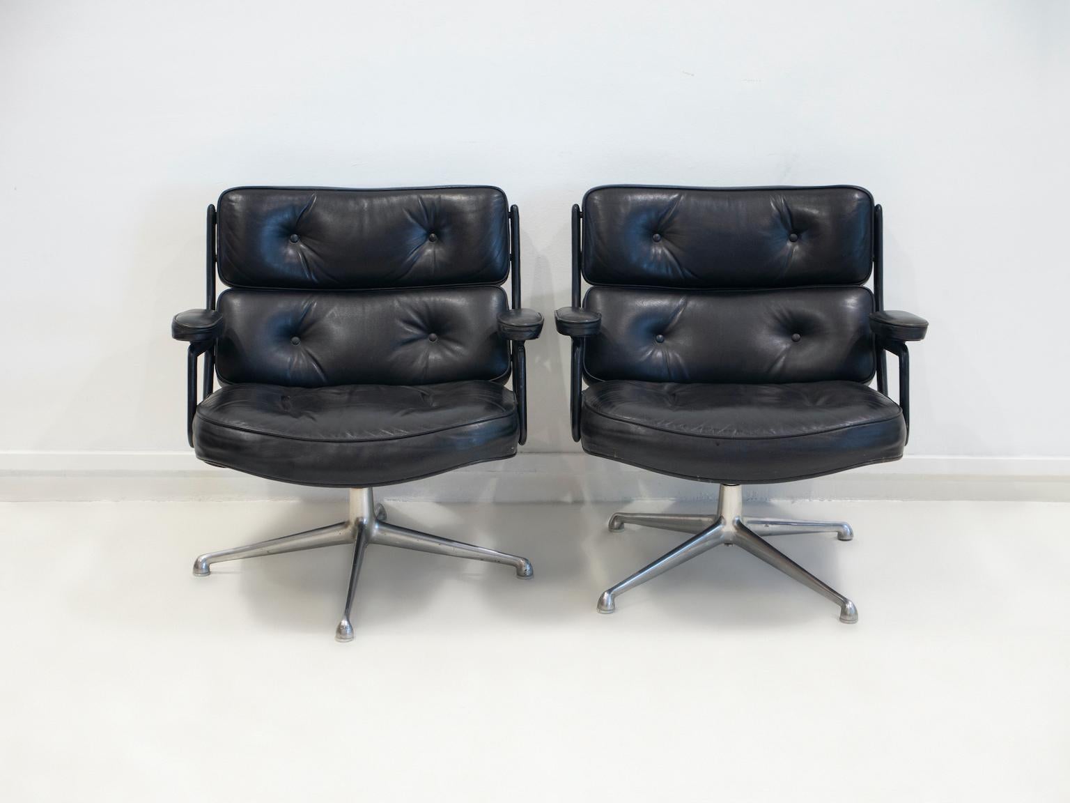 Paar schwarze ledergepolsterte Drehsessel, Modell ES 108, entworfen von Charles & Ray Eames, hergestellt von Vitra. 
Der Lobby Chair wurde 1960 für den Empfangsbereich des Time Life Gebäudes in New York entworfen. 
Gestell aus poliertem Aluminium,