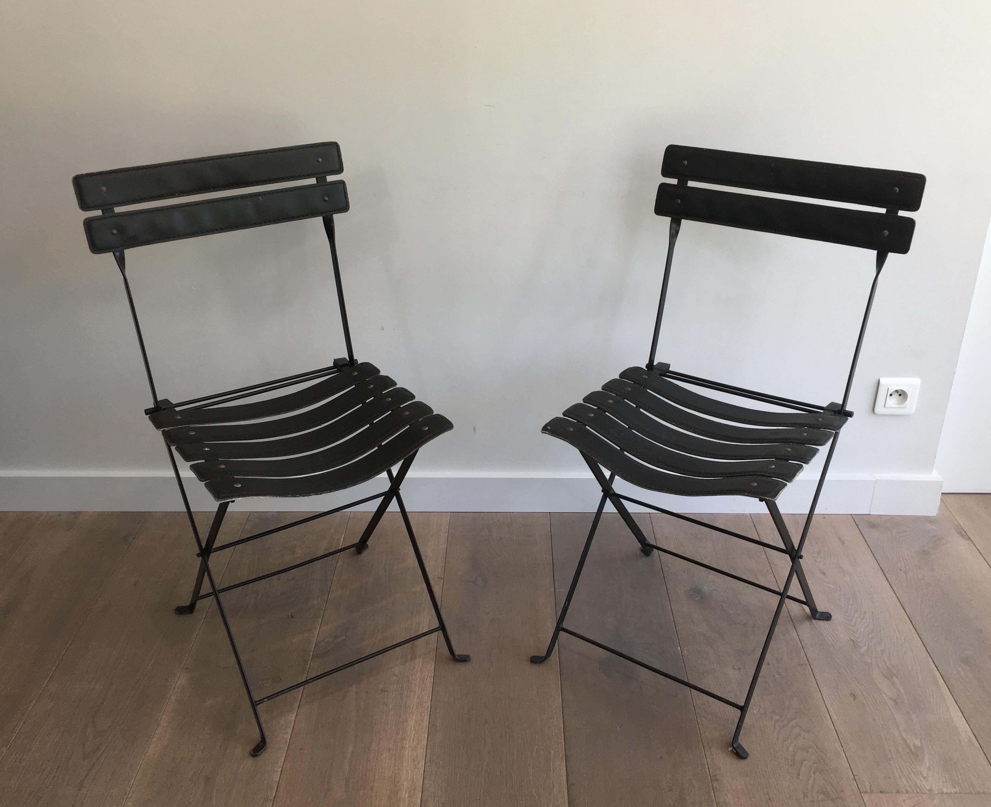 Paire de chaises en cuir noir et métal. Vers 1950.