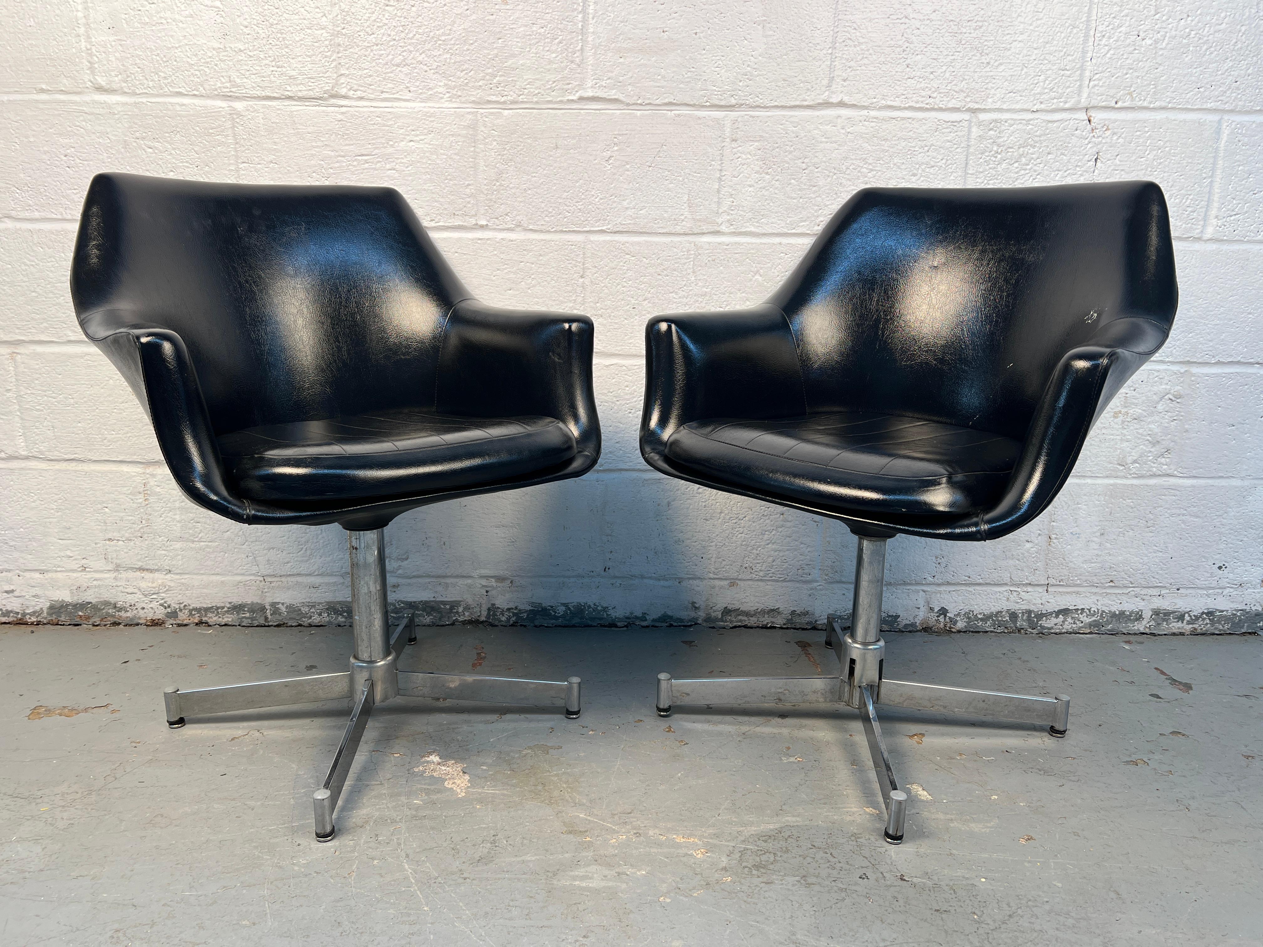 Élégante paire de fauteuils pivotants de style moderne du milieu du siècle, revêtus de cuir noir lisse. Dotés de lignes épurées et d'une forme sculpturale confortable, ils ajoutent une touche moderne et élégante à tout salon, bureau ou espace de