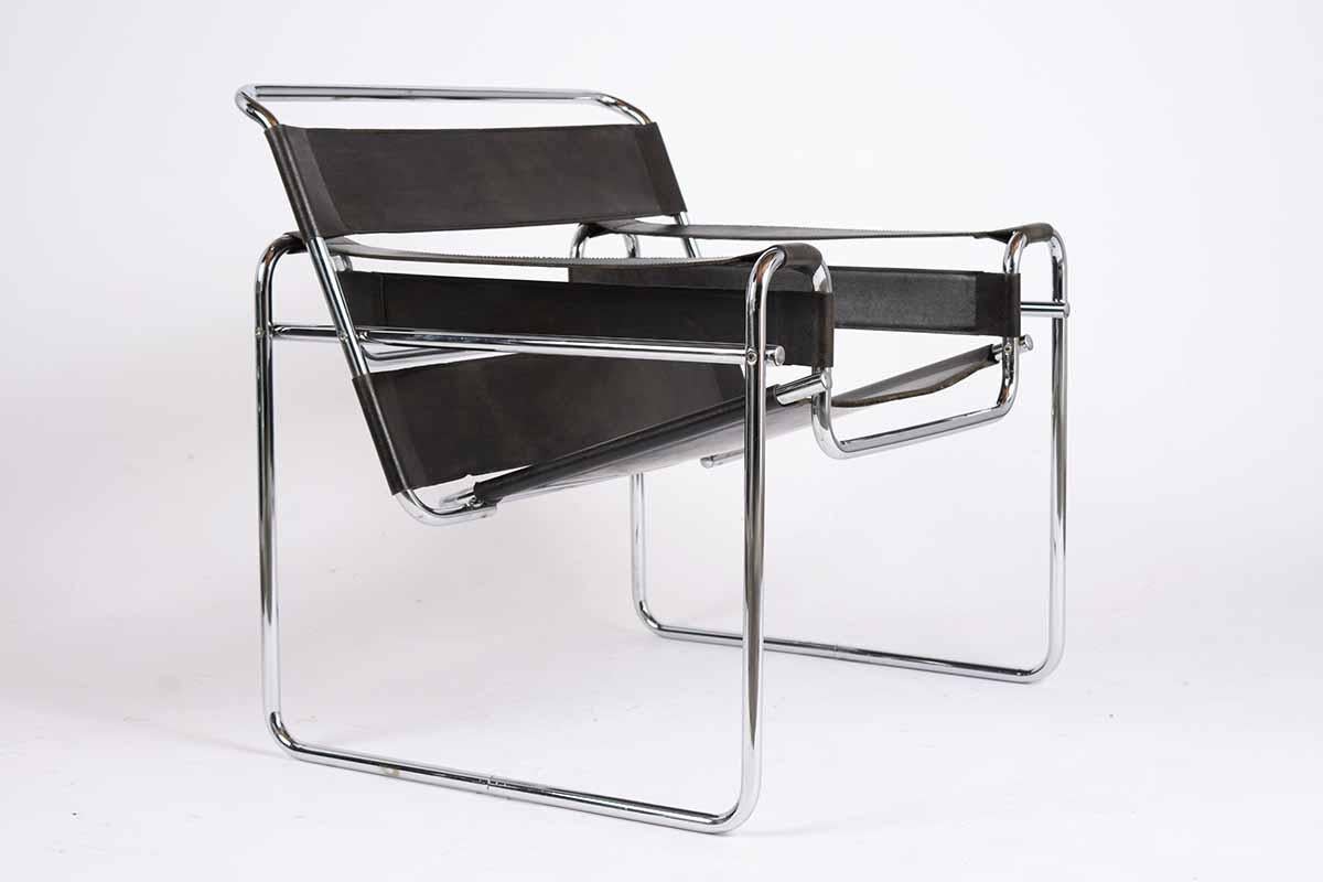 This Unique Set of 1970’s Vintage Lounge Chairs have been crafted in the widely known Wassily style. These sleek armchairs feature minimalistic chrome frames with black leather bands that create the seat, seatback, and armrests. This Vintage Pair of
