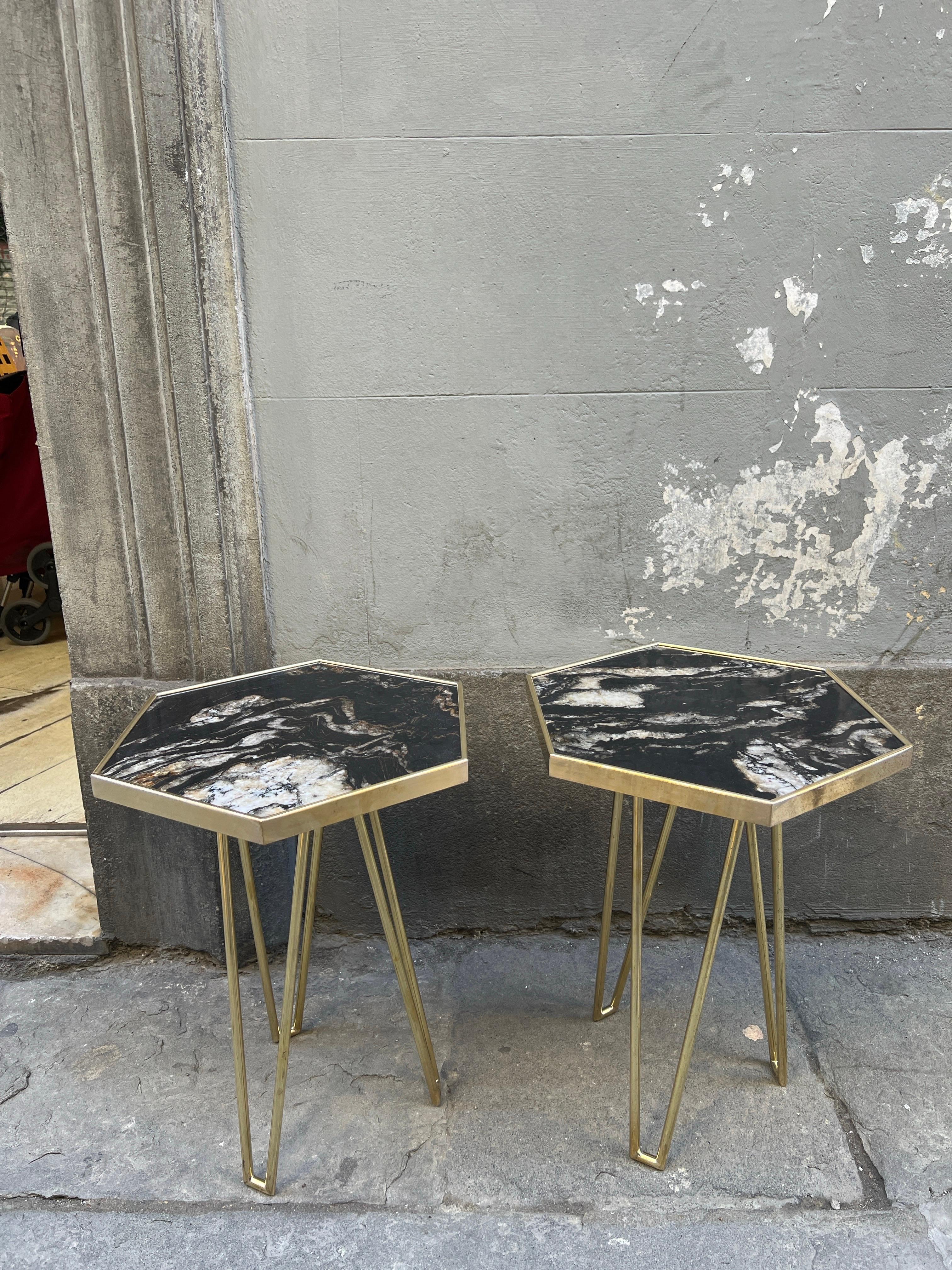 Pair of Black Marble Hexagonal Side/End Tables with Brass Structure.
The marble top in made of Black Marble with white and some bronze veins,  the top has a brass frame and the legs of the tables are made of brass.