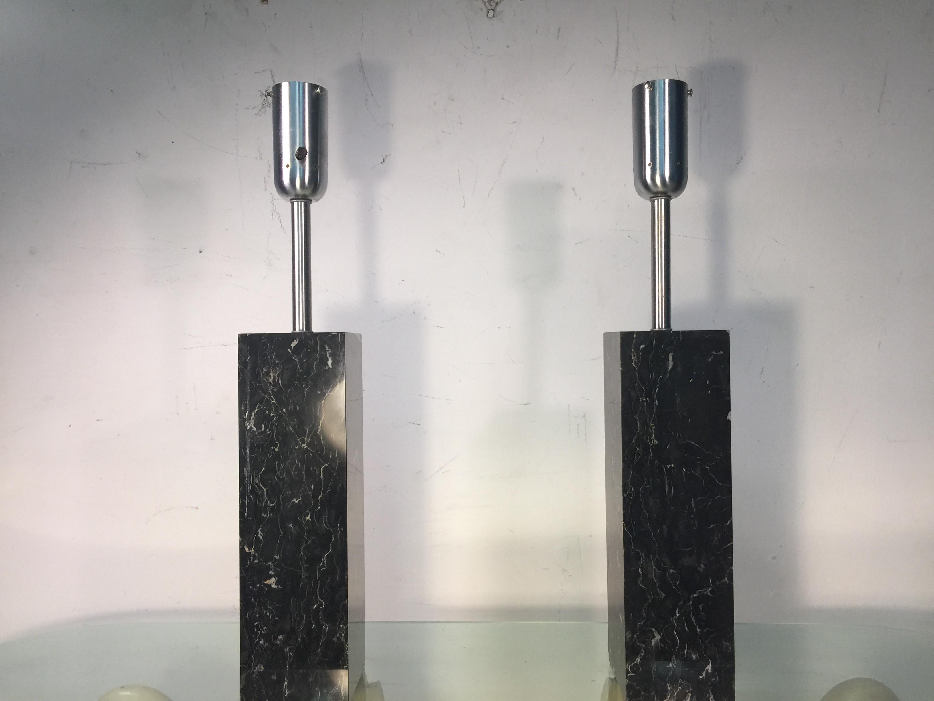 Modern solid black marble rectangular lamps designed in the 1970s by the Nessen Lamp Company. Fitted with nickel-plated fixtures that hold a white glass fitter shade. Both marble bases are in very good condition with some minor very slight chips.