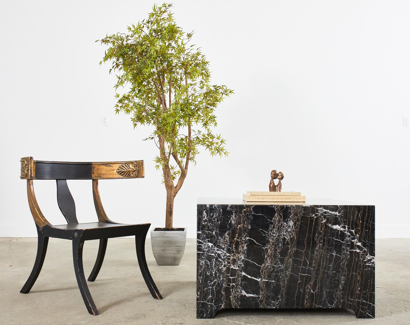 Dramatic pair of black square block coffee, cocktail, or center tables with a variegated finish. The tables appear as two solid blocks with smooth edges and polished finishes. The marble is variegated with intricate gilt, bronze, grey, and white