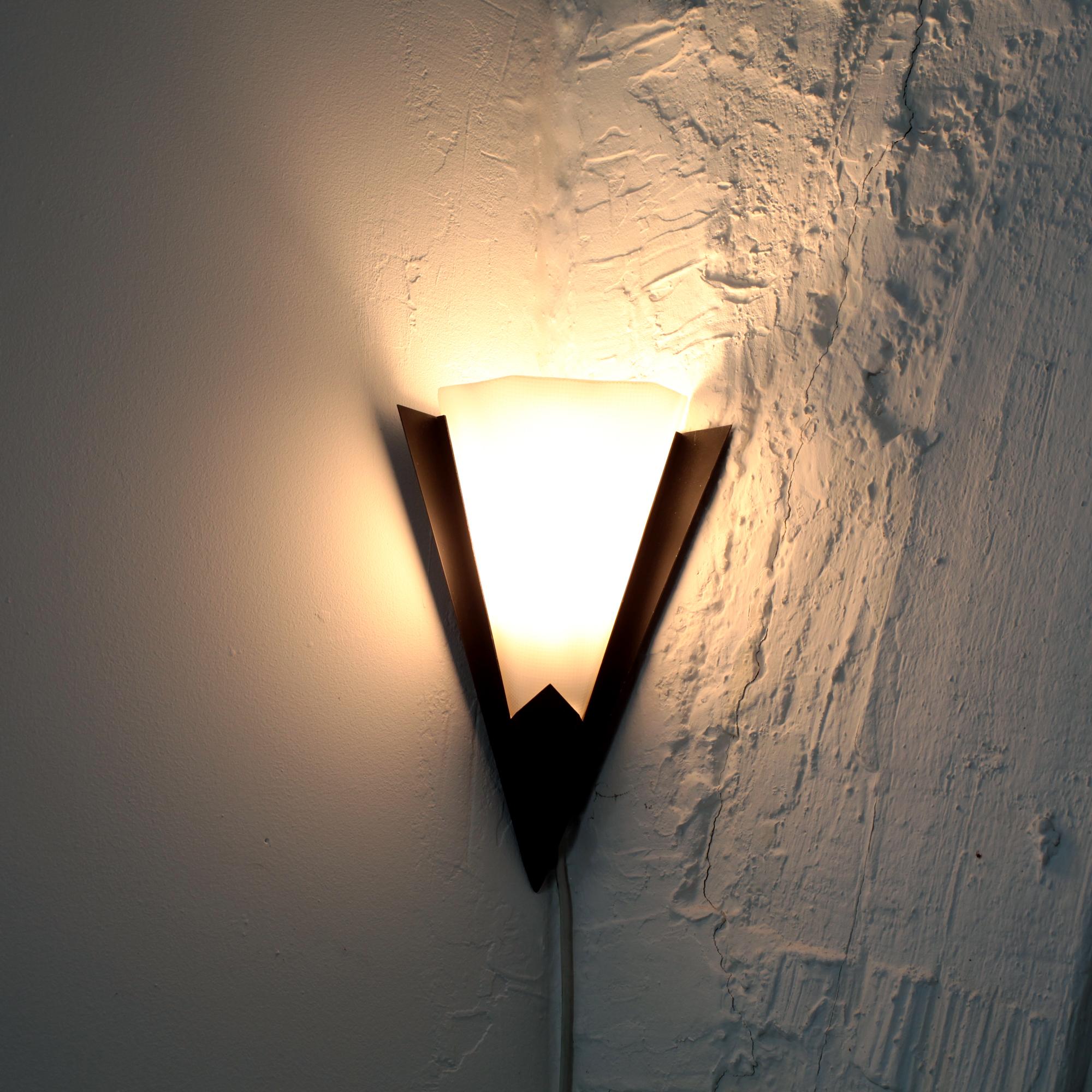 Very rare pair of elegant corner wall lights edited by Pierre Disderot attributed to Pierre Guariche. France 1960.
Geometric black lacquered metal structure with milky white textured plexiglass shade. E14 bulb not included.

Pierre Disderot holds a