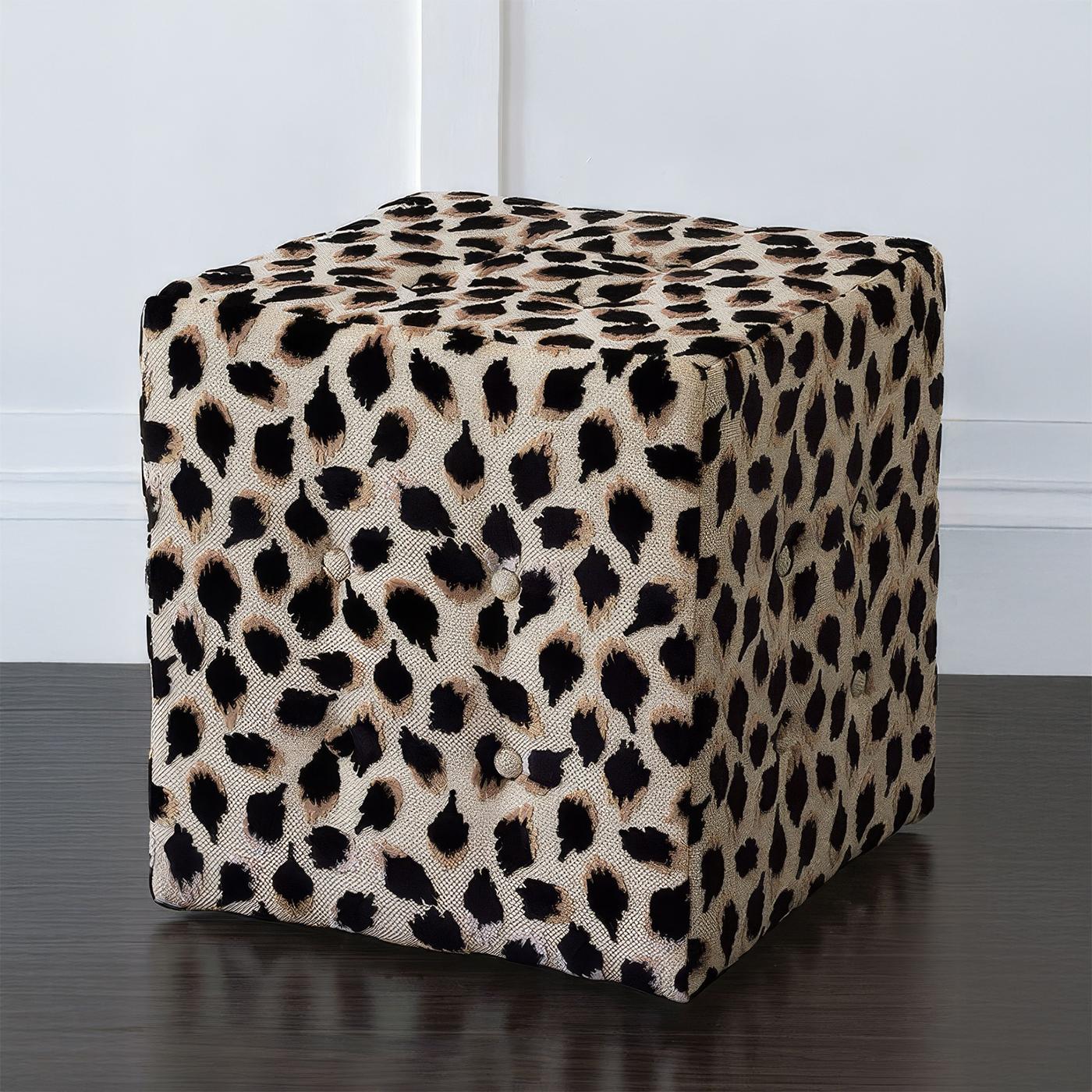 A bold, compact accent piece, upholstered in luxury animal print fabric with hand-tufted fabric-covered buttons. Its striking black ocelot pattern adds an untamed elegance to any space.

Proudly Made in the USA, this ottoman is crafted for