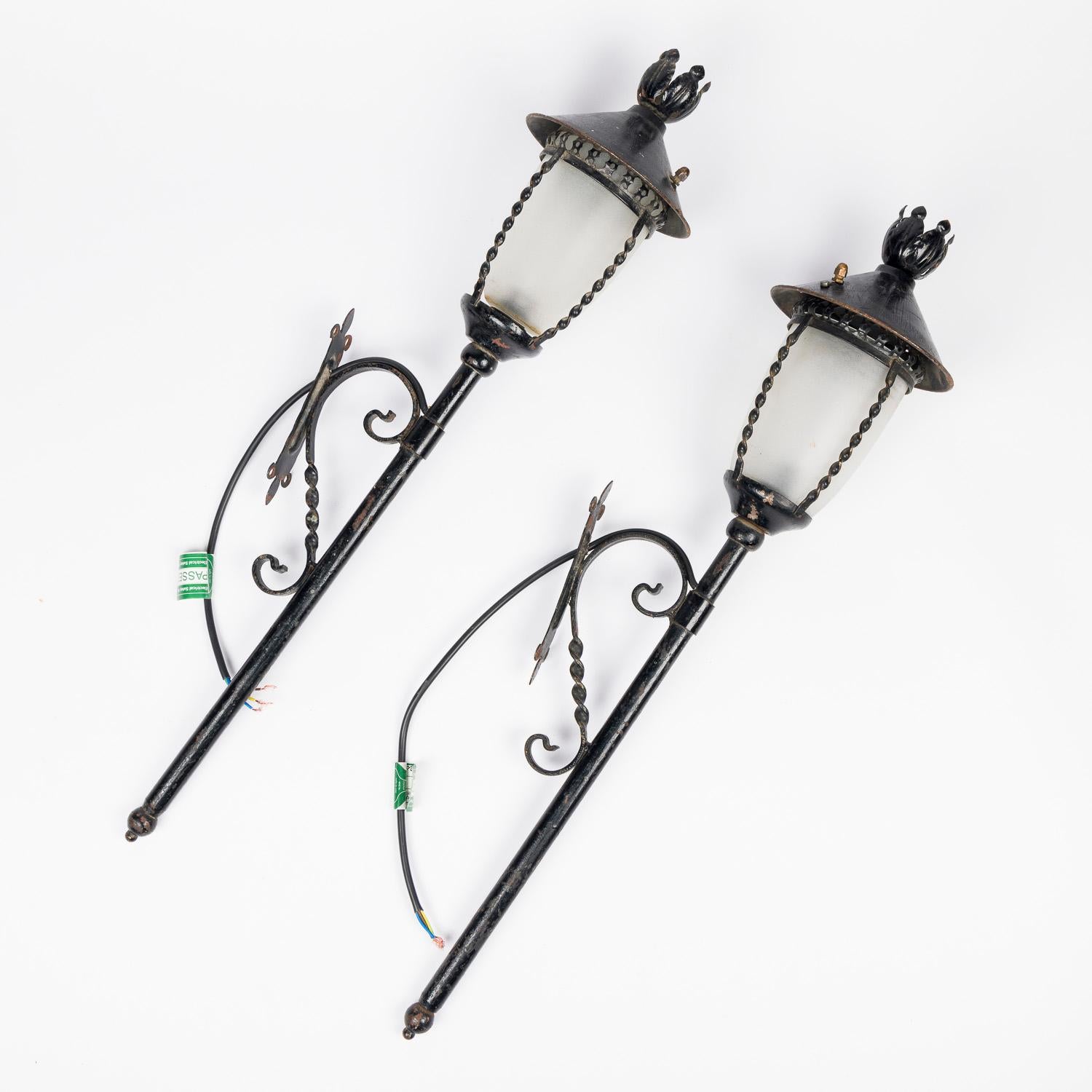 Pair of black painted wrought iron wall lights, with frosted shades. For Sale 2