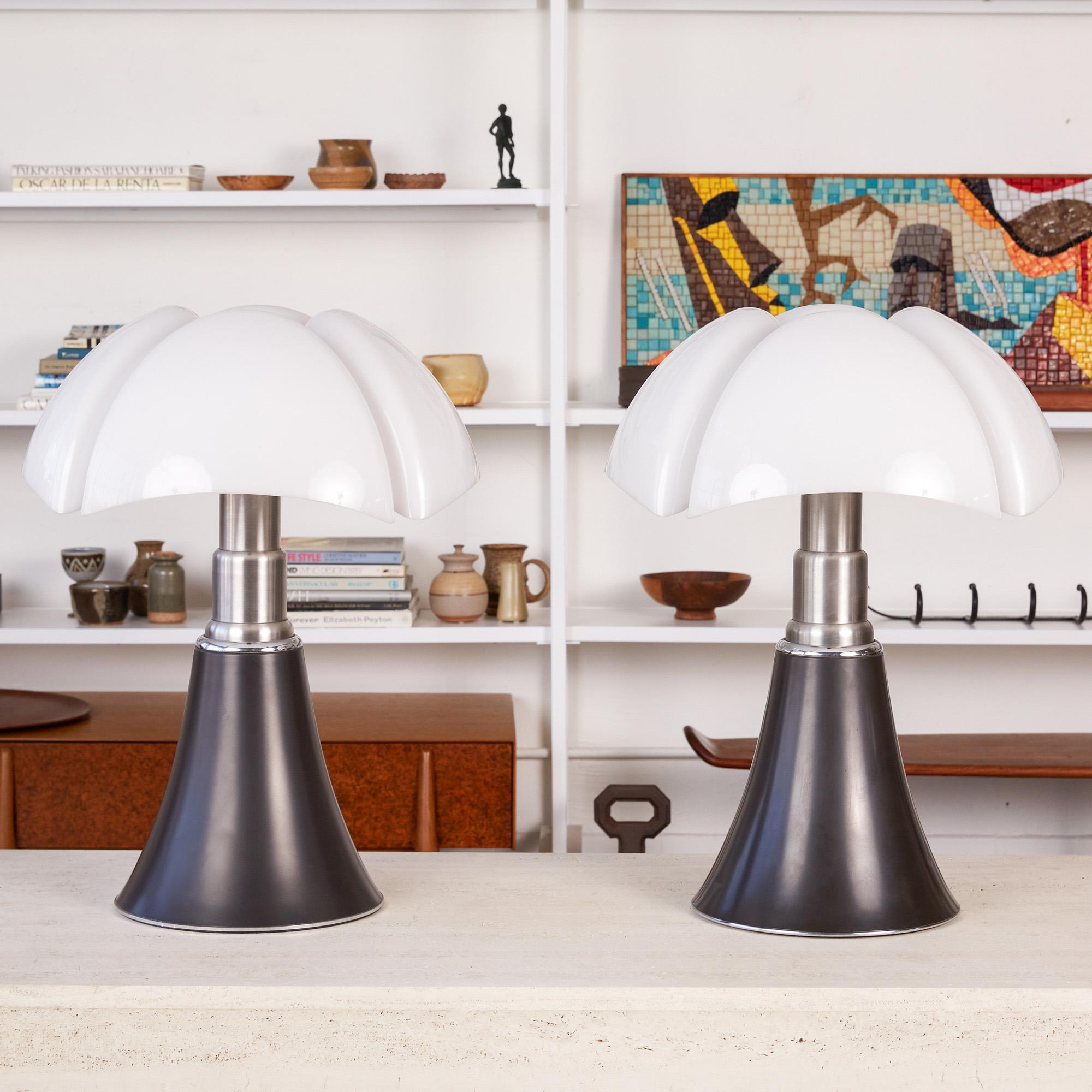 Pipistrello table lamp by Gae Aulenti for Martinelli Luce. The model 620 lamp was designed in 1965 by the Italian design maestro and has remained a steadfast Classic for generations. Each lamp features a sculptural opal plastic shade, black painted