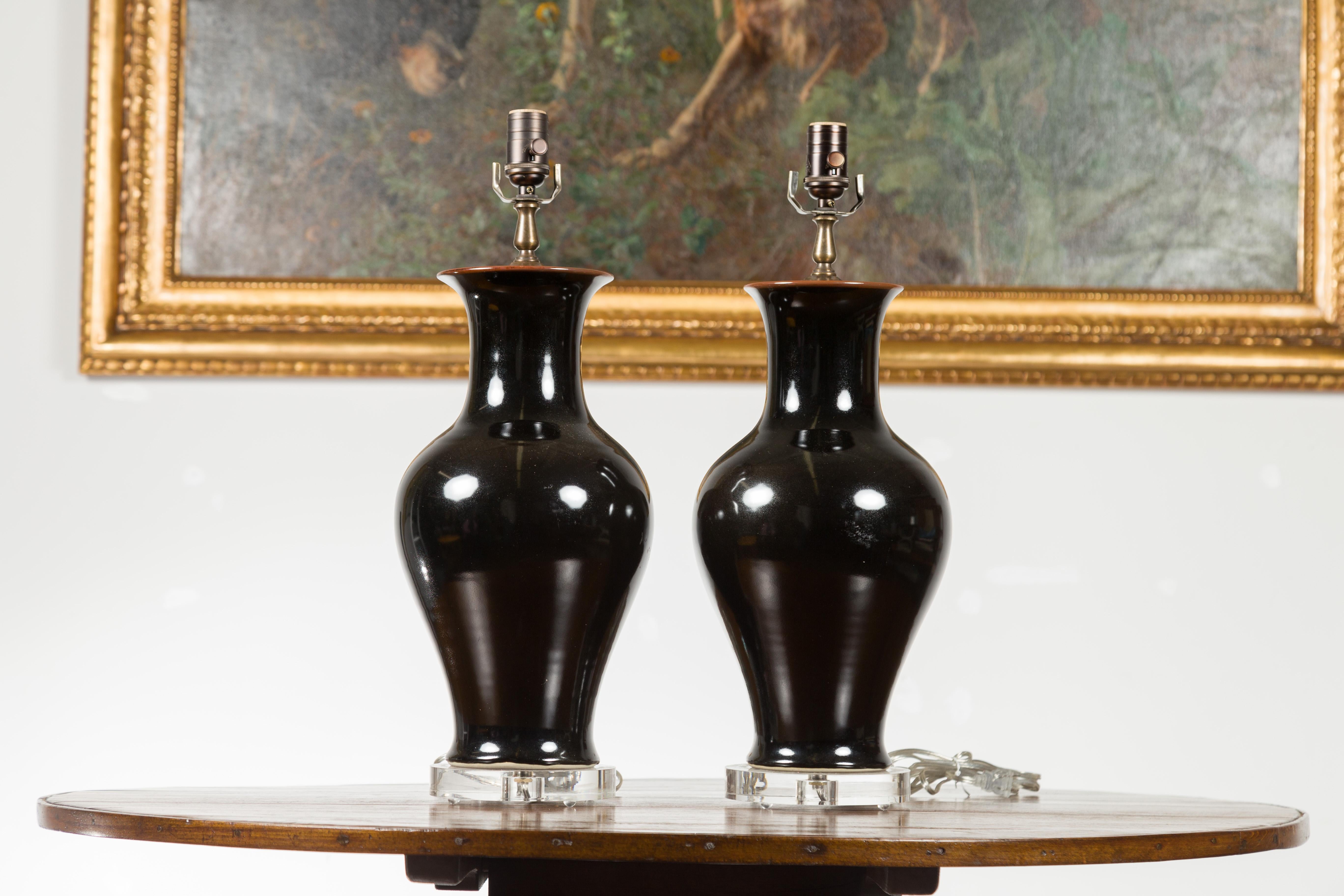 Mid-Century Modern Paire de lampes de bureau en forme de vase en porcelaine noire avec bases rondes en lucite, câblées en vente