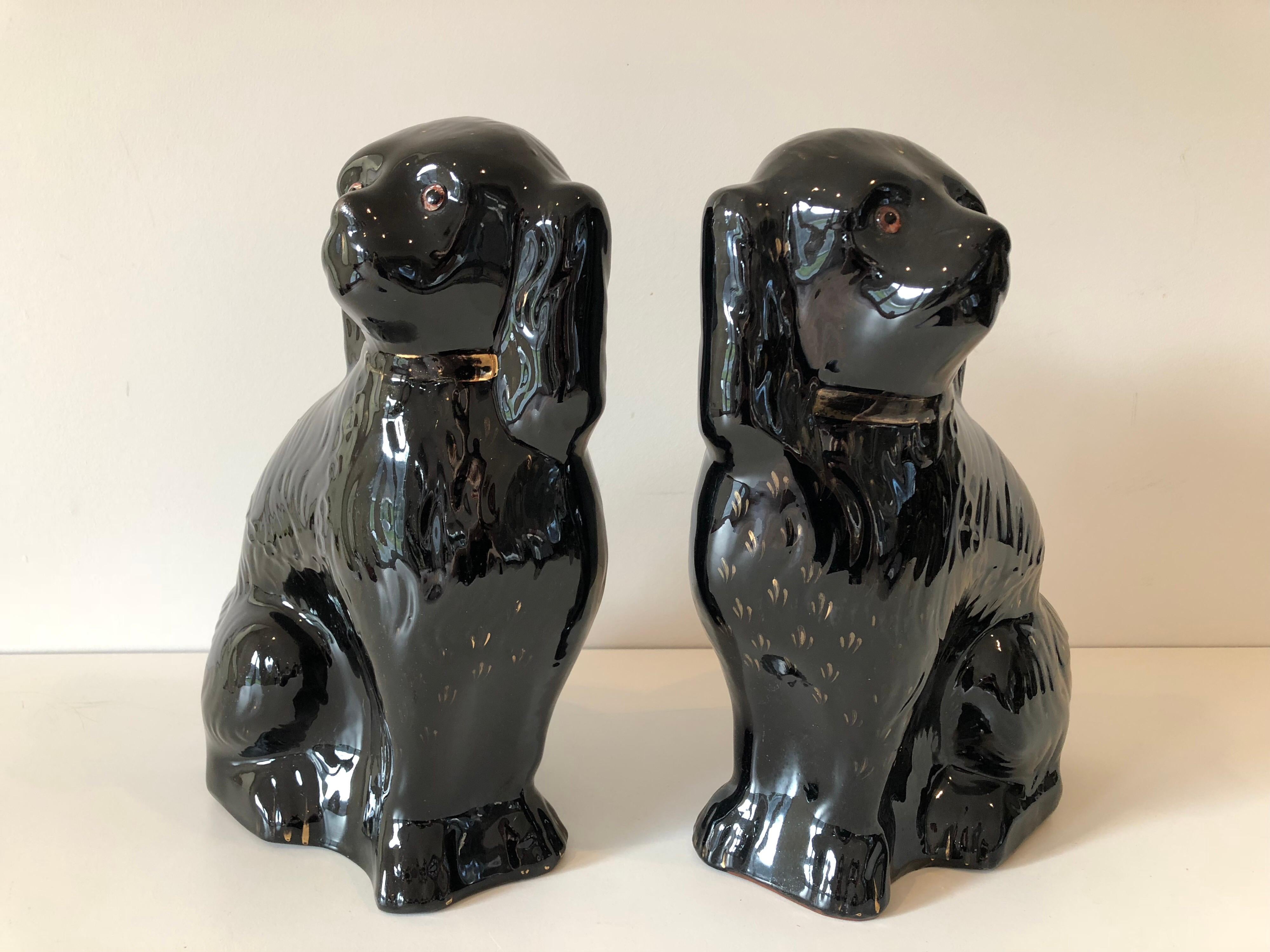 A pair of large black glazed ceramic Staffordshire spaniels by Sadler, England. Original condition with gold glazed detail and glass eyes. A large and impressive example.