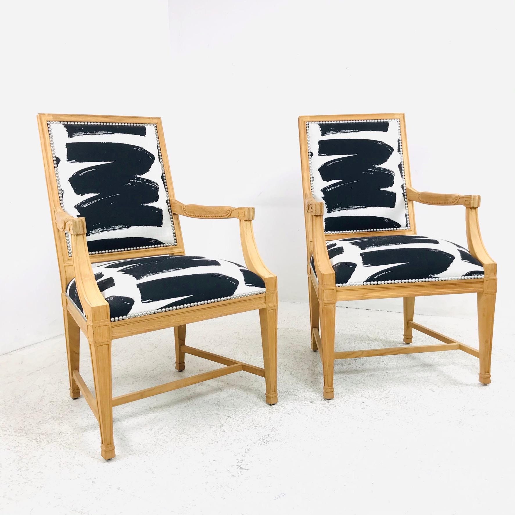 Coppia di poltrone contemporanee in legno intagliato in stile Luigi XVI con dettagli a chiave greca e decorazioni in testa di chiodo. Rivestita di recente in tessuto bianco e nero; buone condizioni di utilizzo. *Si prega di notare che il