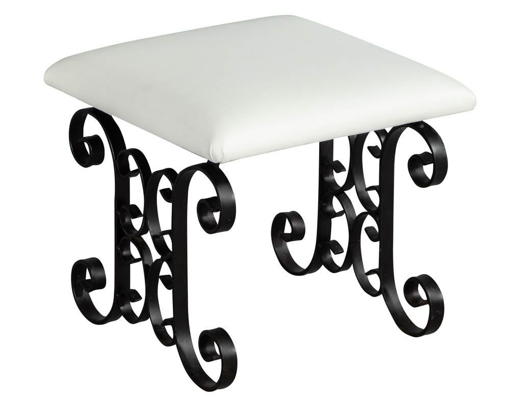 Pair of black wrought iron Tudor style stools. Newly upholstered in white leather.