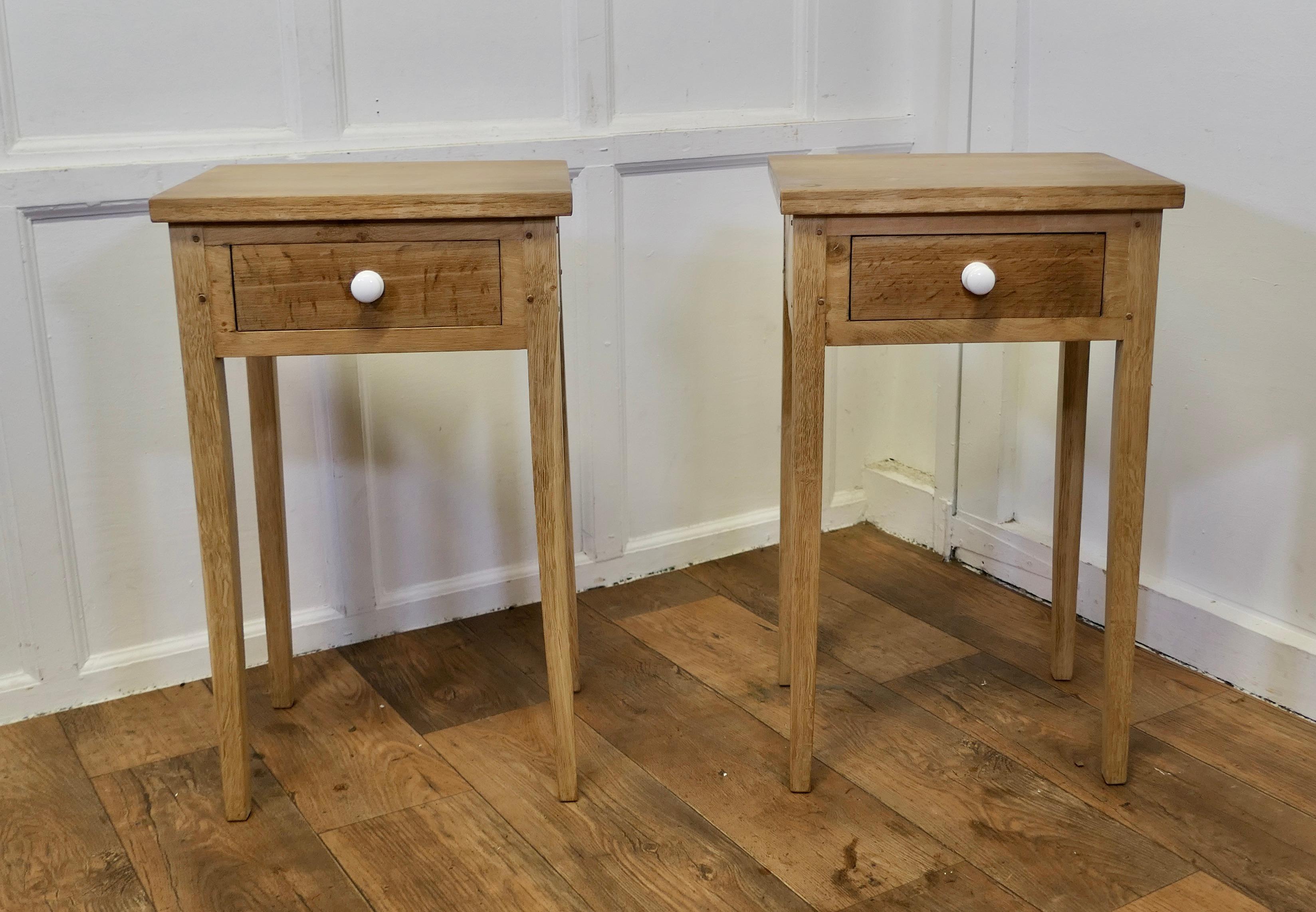  Pair of Bleached Oak Mid Century Bedside Tables

A pair of Blonde Oak bedside tables, night stands on square tapering legs legs, the tables each have a drawer with a ceramic knob
The cabinets are good sound country made pieces 
The tables stand 29”