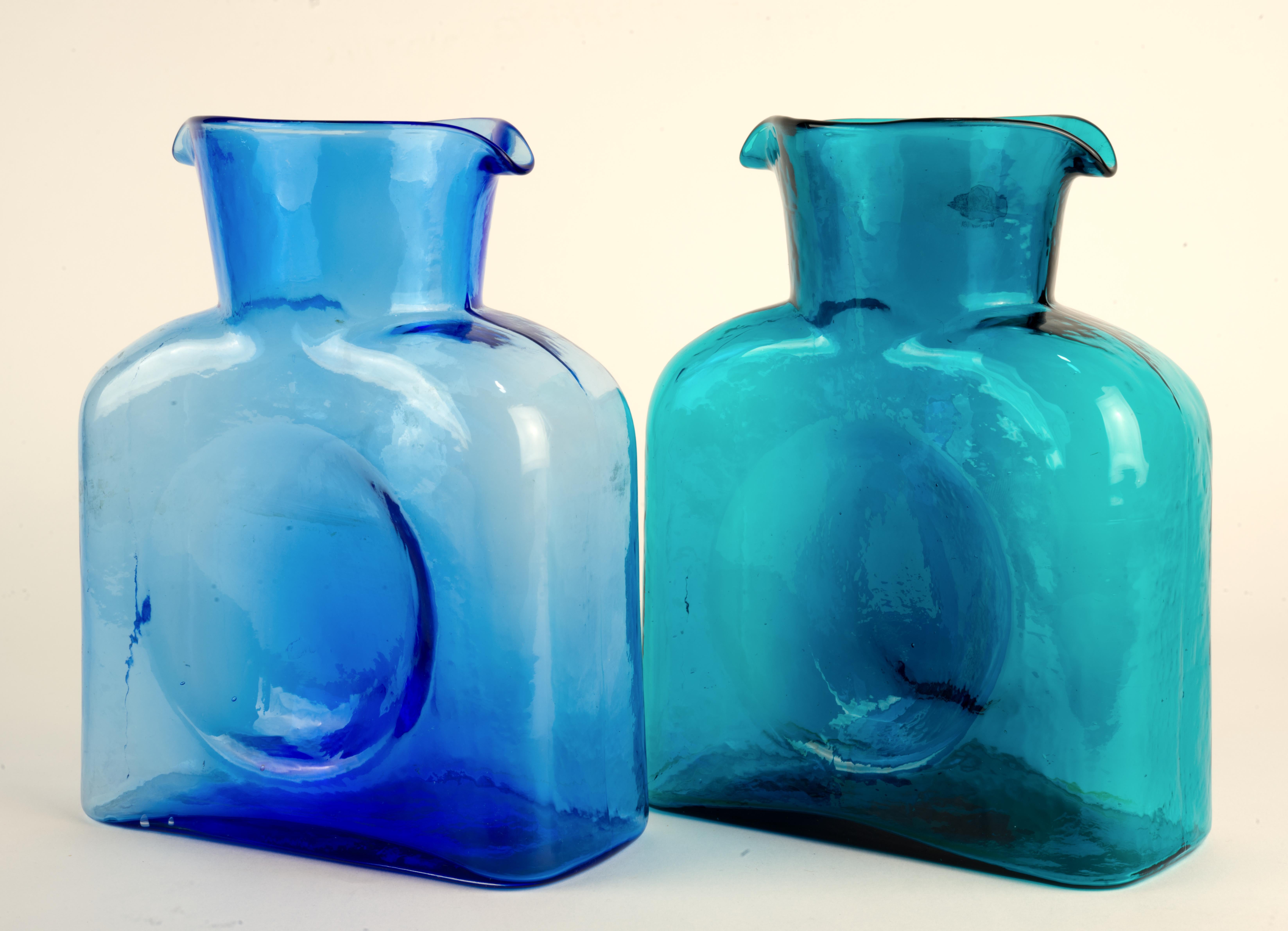  Pair of 384 double spouts water bottles was hand made by Blenko in currently discontinued colors of Azure and Seabreeze. 

Azure was first introduced from 1985 to 2005, and it was returned to the catalogue until 2020. It is a Cased color, with a