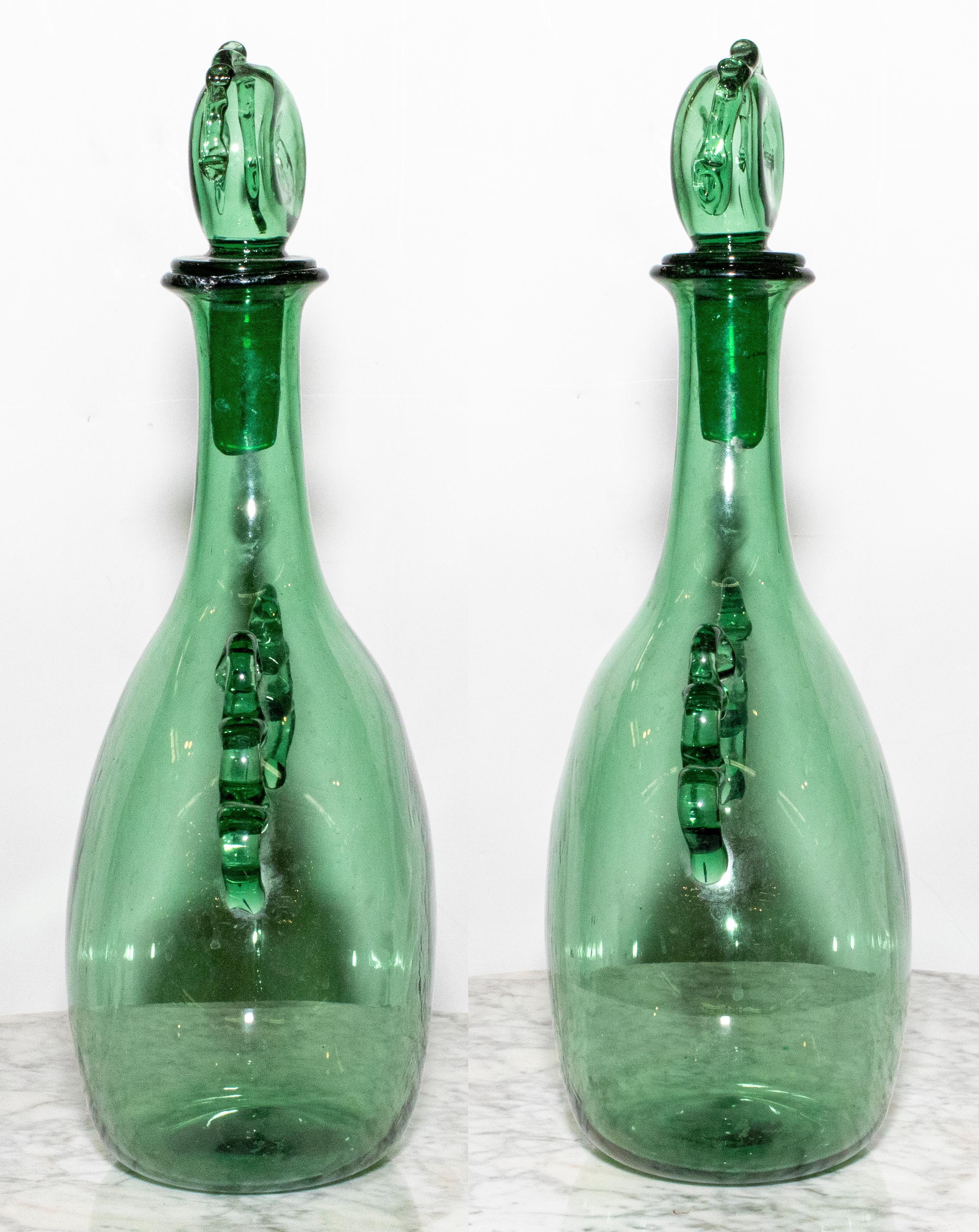 Pair of 1970s Blenko green glass decanters with elaborate decoration. Hand blown with elaborate stoppers.