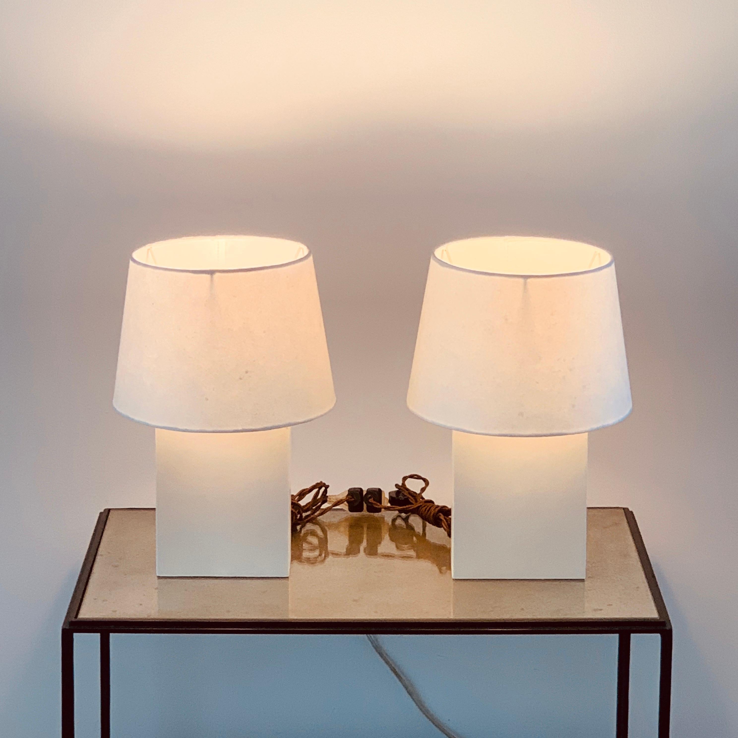 Pair of 'Bloc' parchment lamps with parchment paper shades by Design Frères.

The overall dimensions (base + shade in place) are listed: 10 in diameter x 15 in. tall.

The shade dimensions are 8 in. top diameter x 10 in. bottom diameter x 7 in.