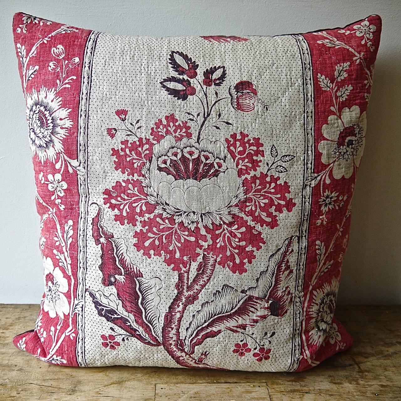 Pair of cushions made from a French, circa 1790s block printed soft cotton and linen mix textile and quilted. A striking design in a pleasing rasberry red and a darker mauve on a picotage ground. Backed in a dyed vintage linen, slipstitched closed