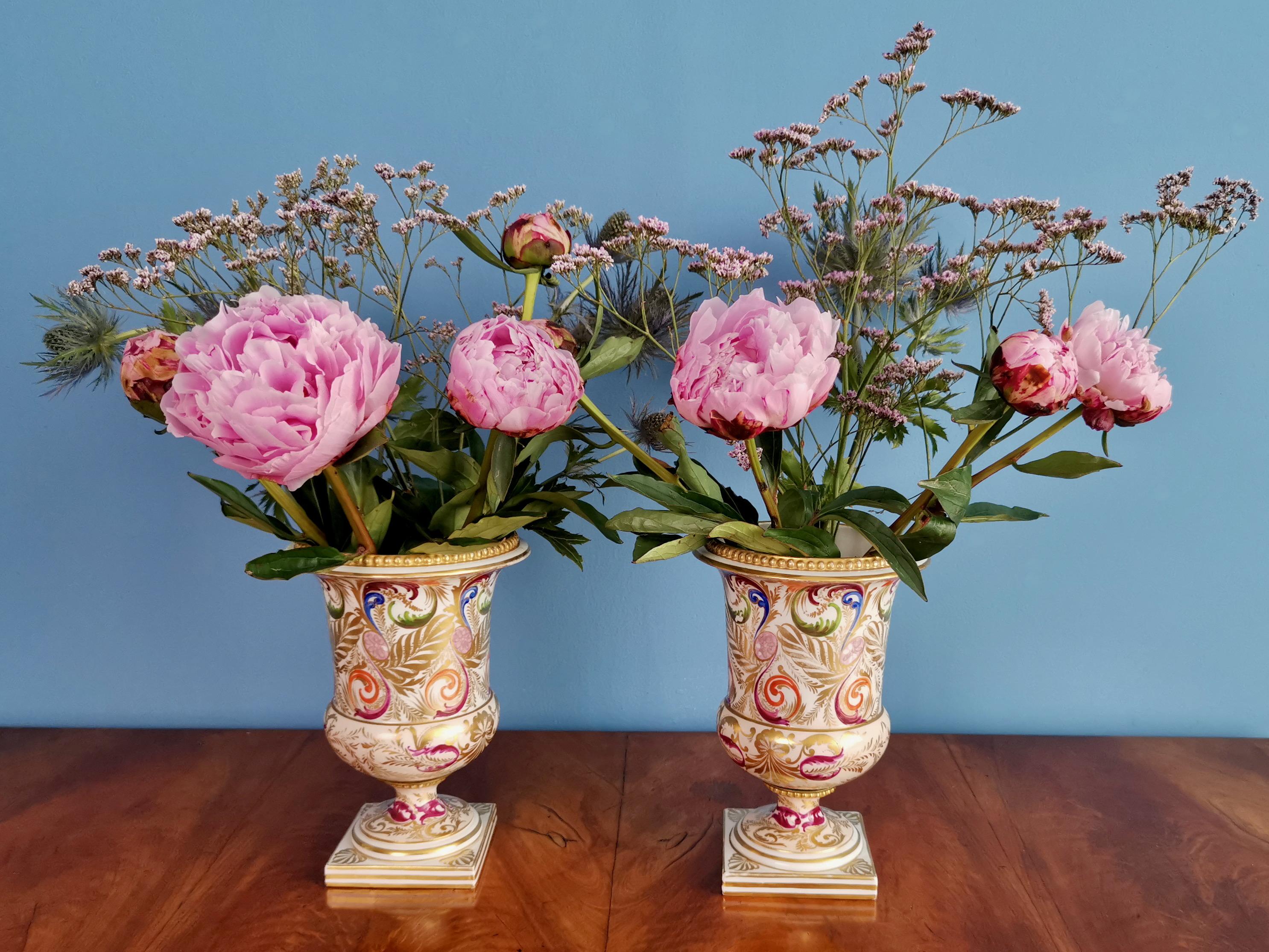 This is a stunning pair of campana vases made by Derby in about 1815, which was the Regency era. The vases have a very rare shape without handles, and are decorated with a typical Regency pattern of polychrome sprigs and gilt details.
 
The Derby