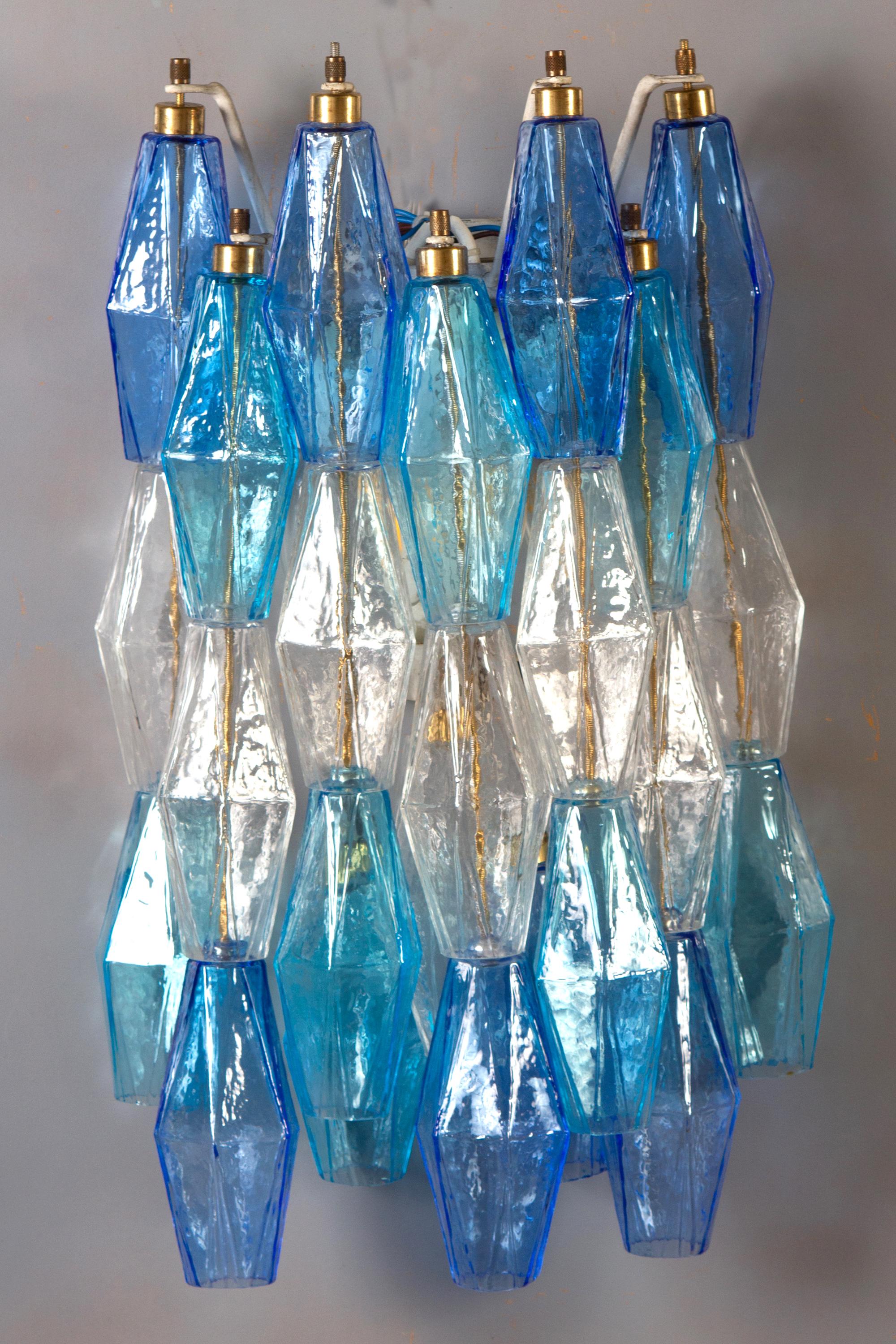 Striking pair of poliedri wall lights. Sapphire color variation with blu and aquamarine precious Poliedri Murano glass.
We can customize the frame, white painted or gold.
Available the pair.
Edition limited from a great master of Venetian