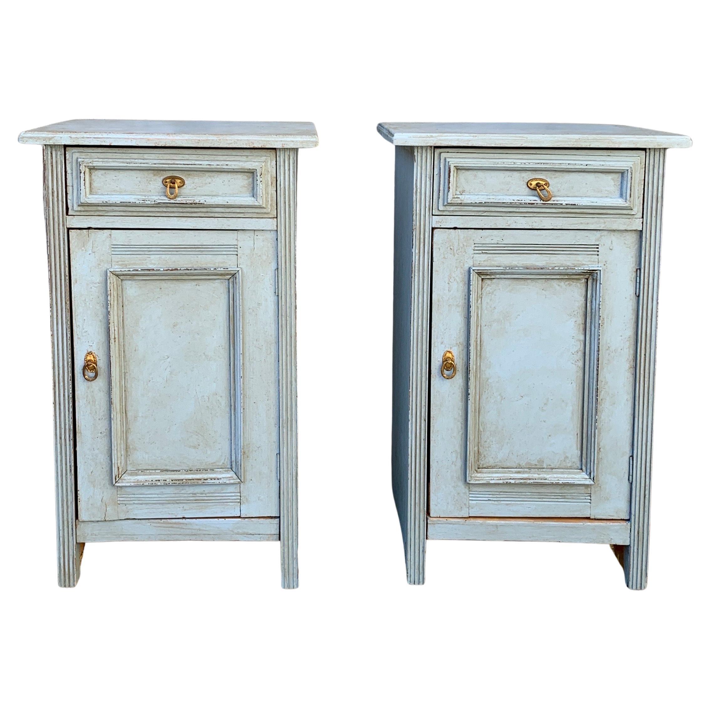 A pair of Gustavian blue painted Swedish nightstands or night tables from the second half of the 19th Century in painted pine wood. These folk art Gustavian style pieces with a charming patina have one clean working drawer to open and one door with