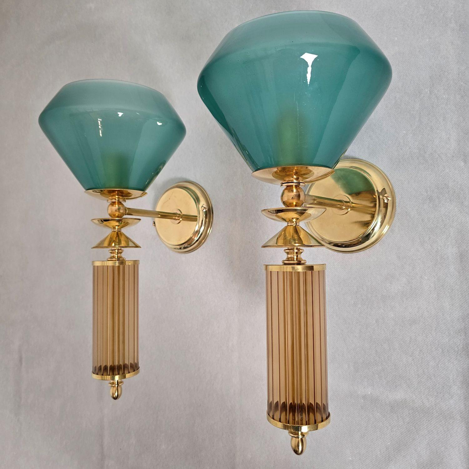 Pair of mid-century modern Murano glass wall sconces, Italy circa 1990s. Vistosi style, Murano.
The pair of Italian sconces is made of petrol blue and beige glass and Murano glass elements.
The mounts are in polished brass.
The top blue-green