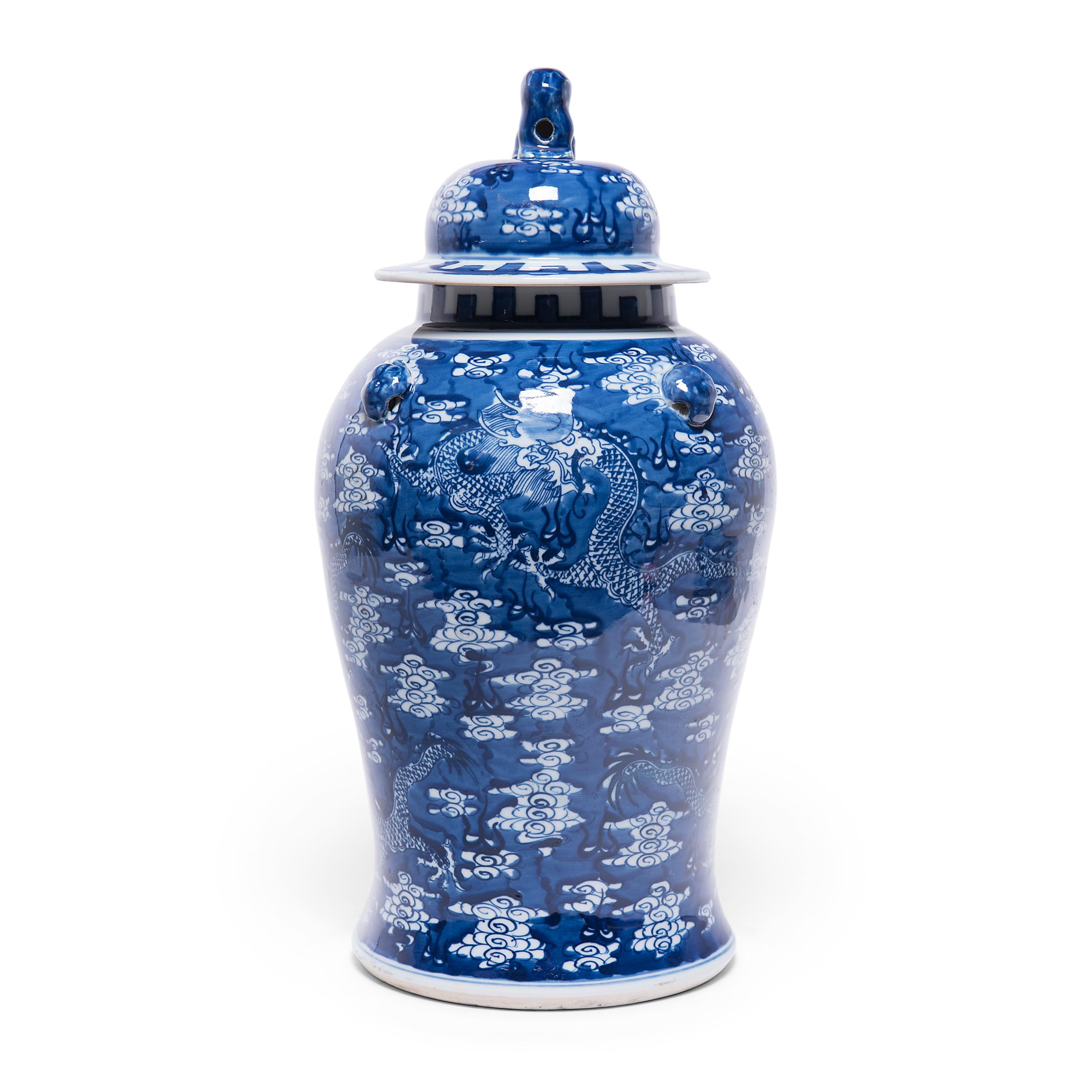 These contemporary lidded baluster jars continue the centuries-old tradition of Chinese blue-and-white porcelain ware. Painted with cobalt pigments for a brilliant blue finish, each jar is decorated with a scene of serpentine dragons soaring through