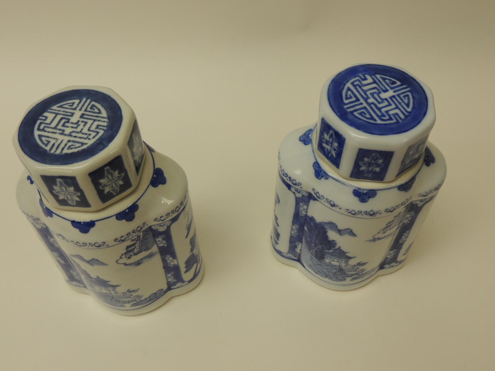 Pair of blue and white ceramic Asian canisters.
Blue and white lidded canisters depicting traditional Asian temple scenery with lids.
Size: 8 x 5.5 x 3.5.